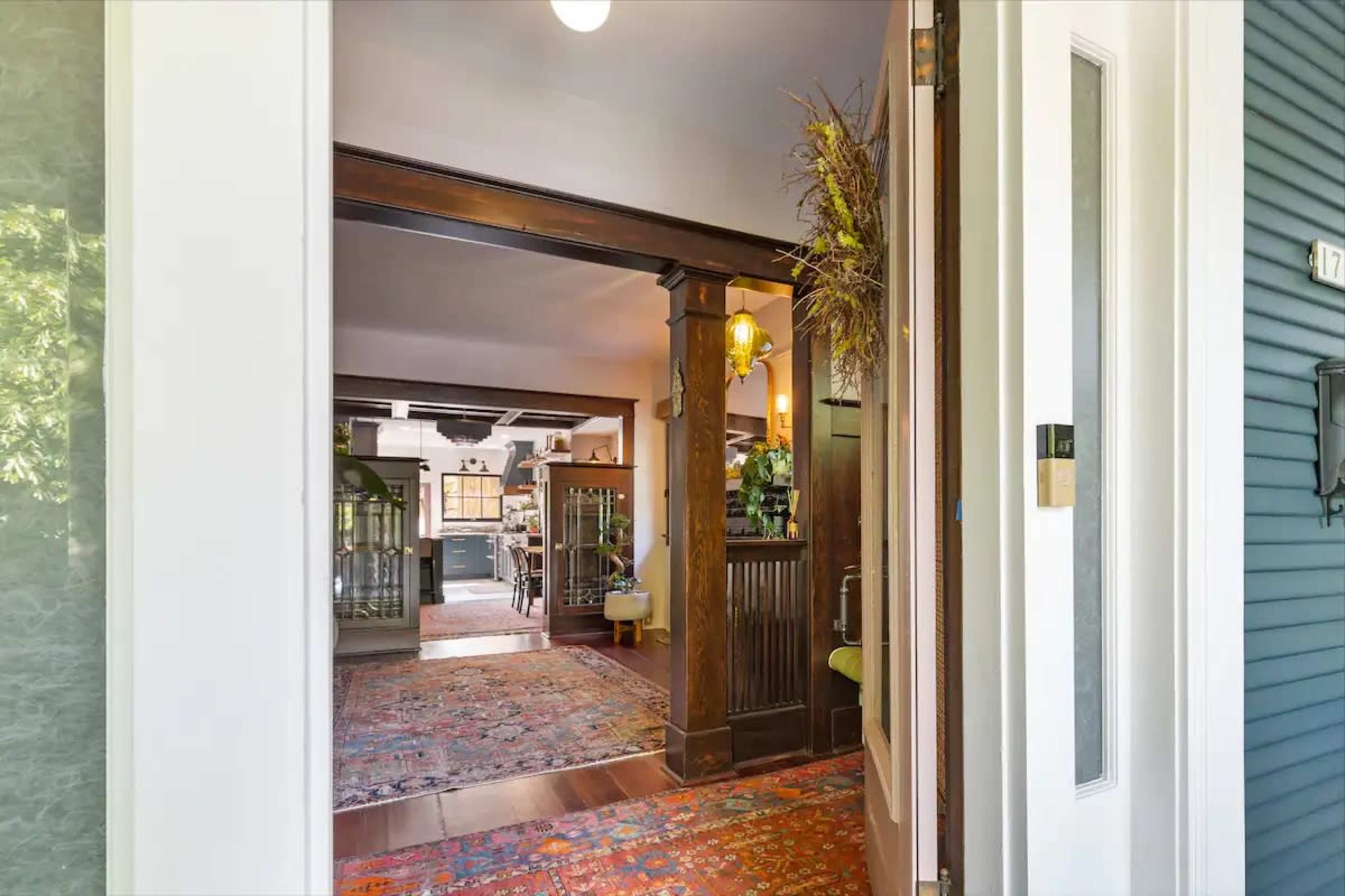 An entrance area leading into a welcoming interior with detailed woodwork and a colorful area rug.
