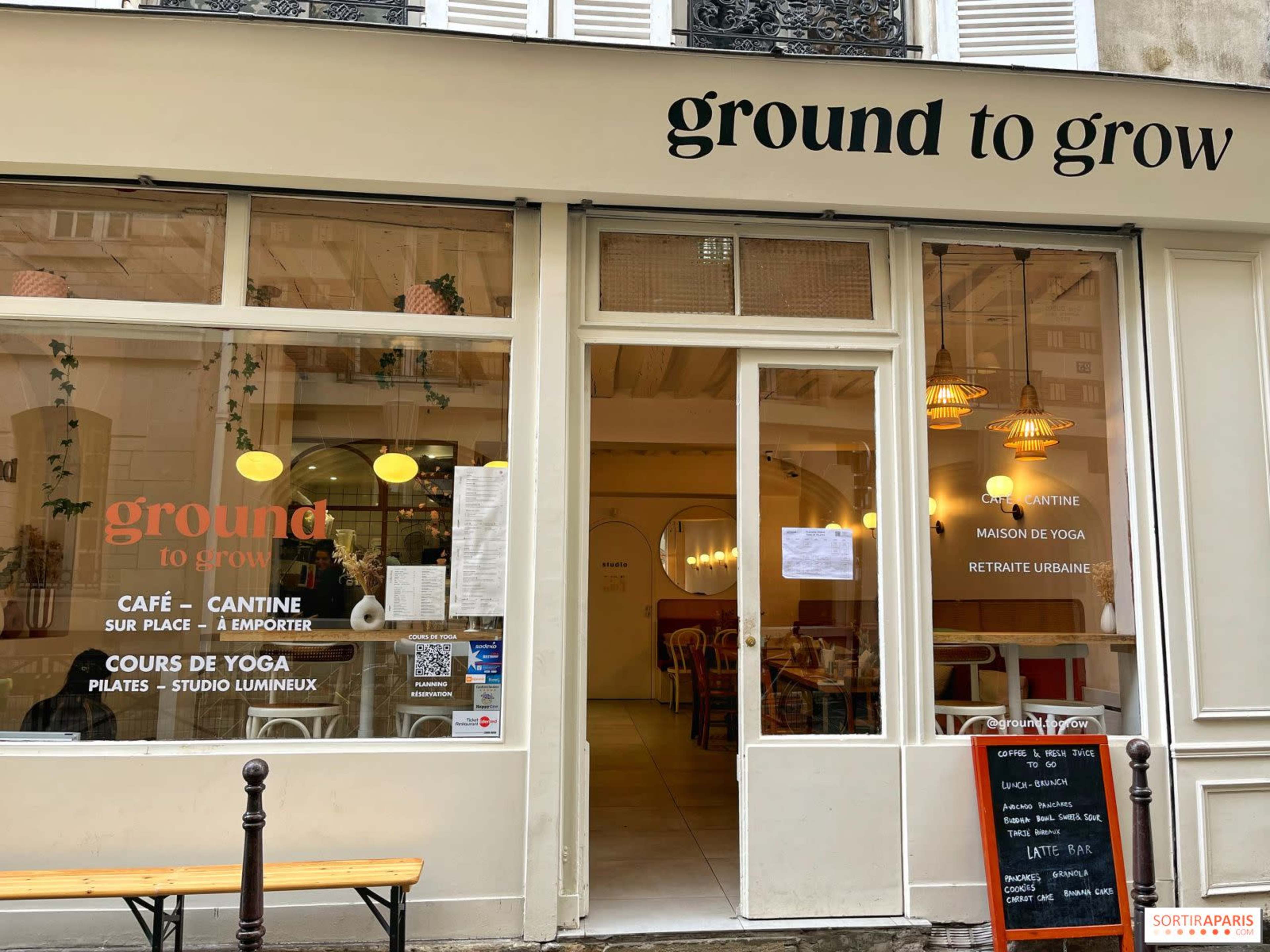 The image shows the storefront of a café called "ground to grow," featuring large windows, a light interior, and a menu board outside.