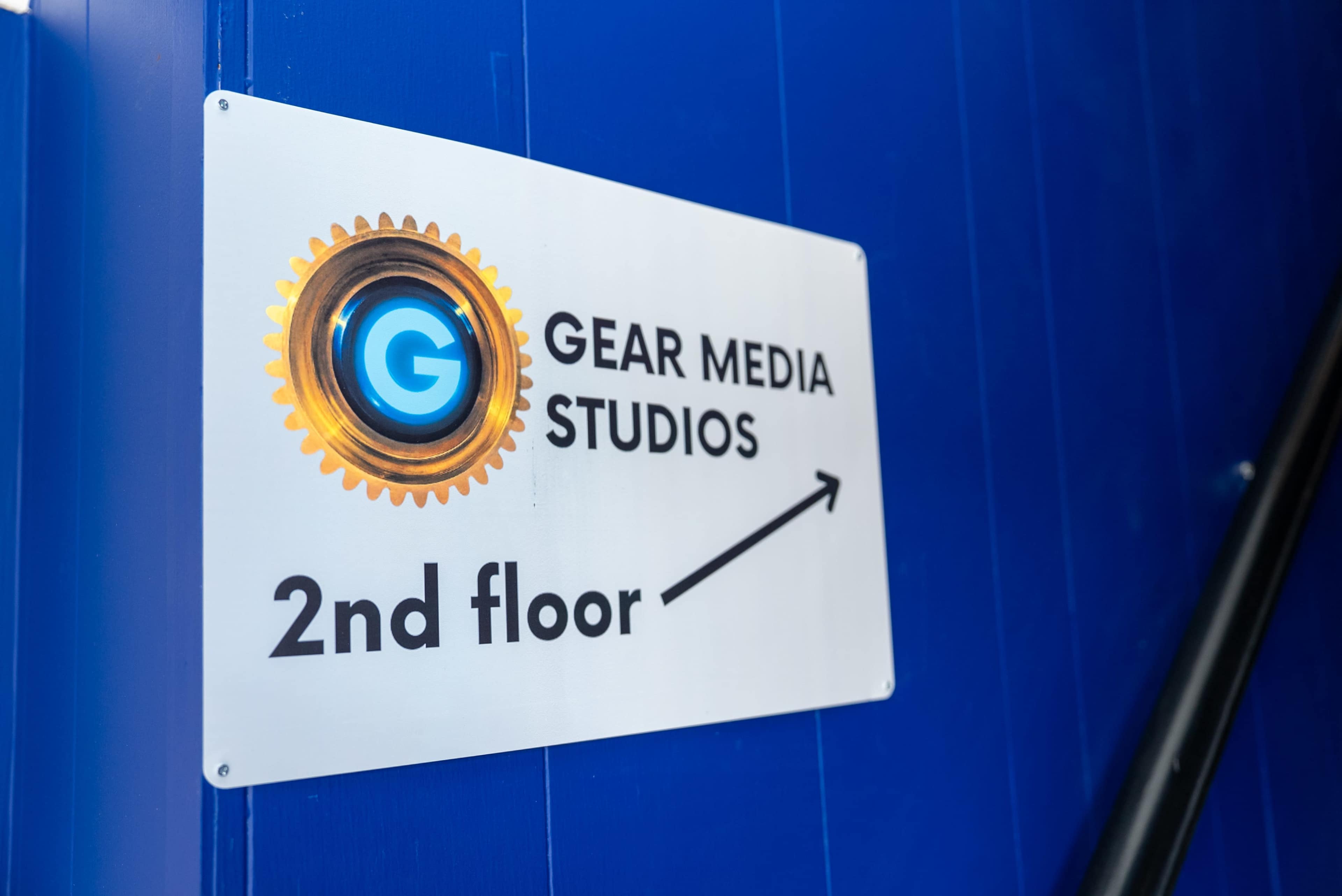 A sign indicates the direction to Gear Media Studios on the second floor.