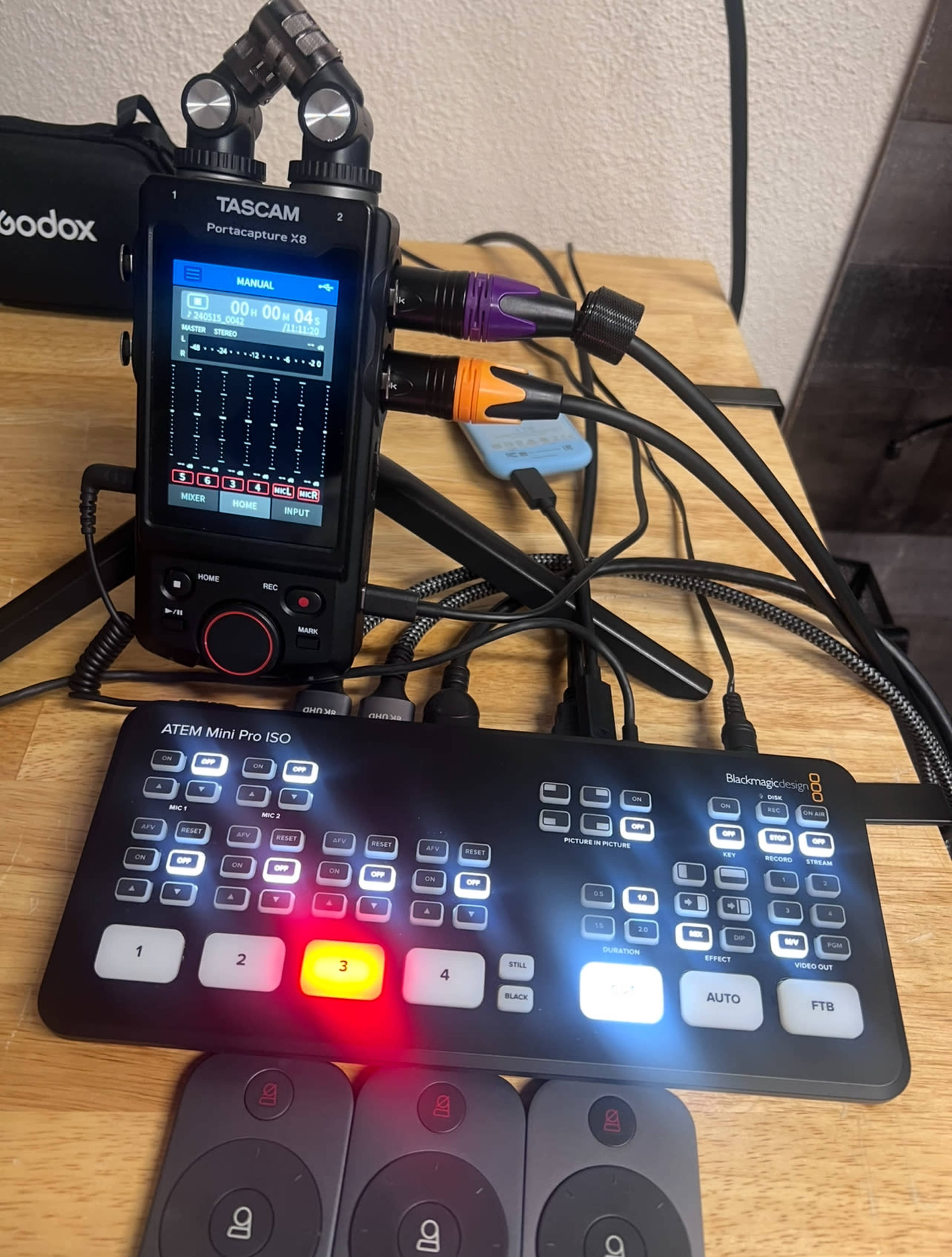 A Tascam Portacapture X8 connected to a Blackmagic ATEM Mini Pro ISO with various cables and controls visible on a wooden surface.