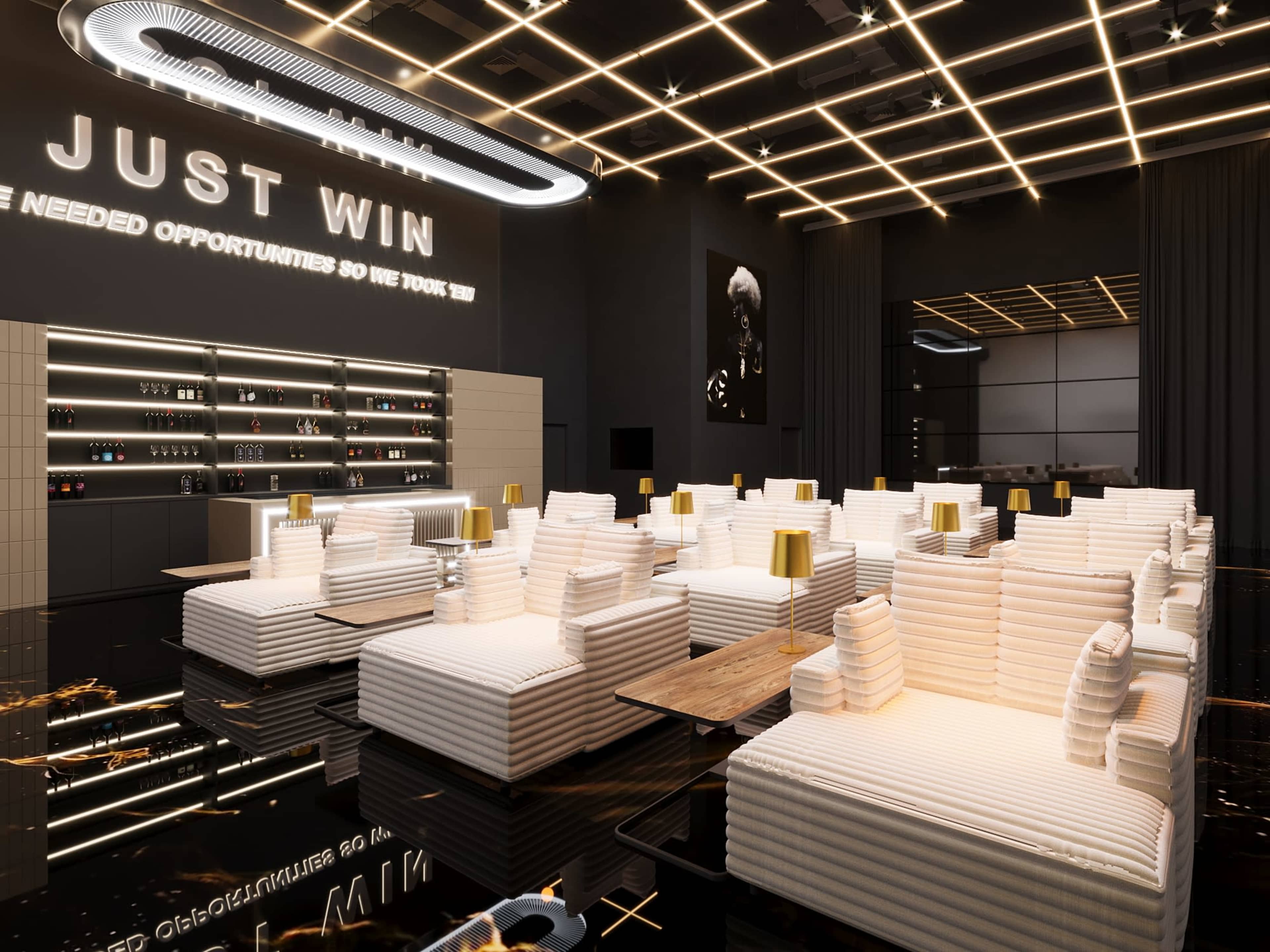 The image shows a modern lounge area with white striped seating, gold accent tables, and illuminated ceiling lights featuring a motivational wall sign.