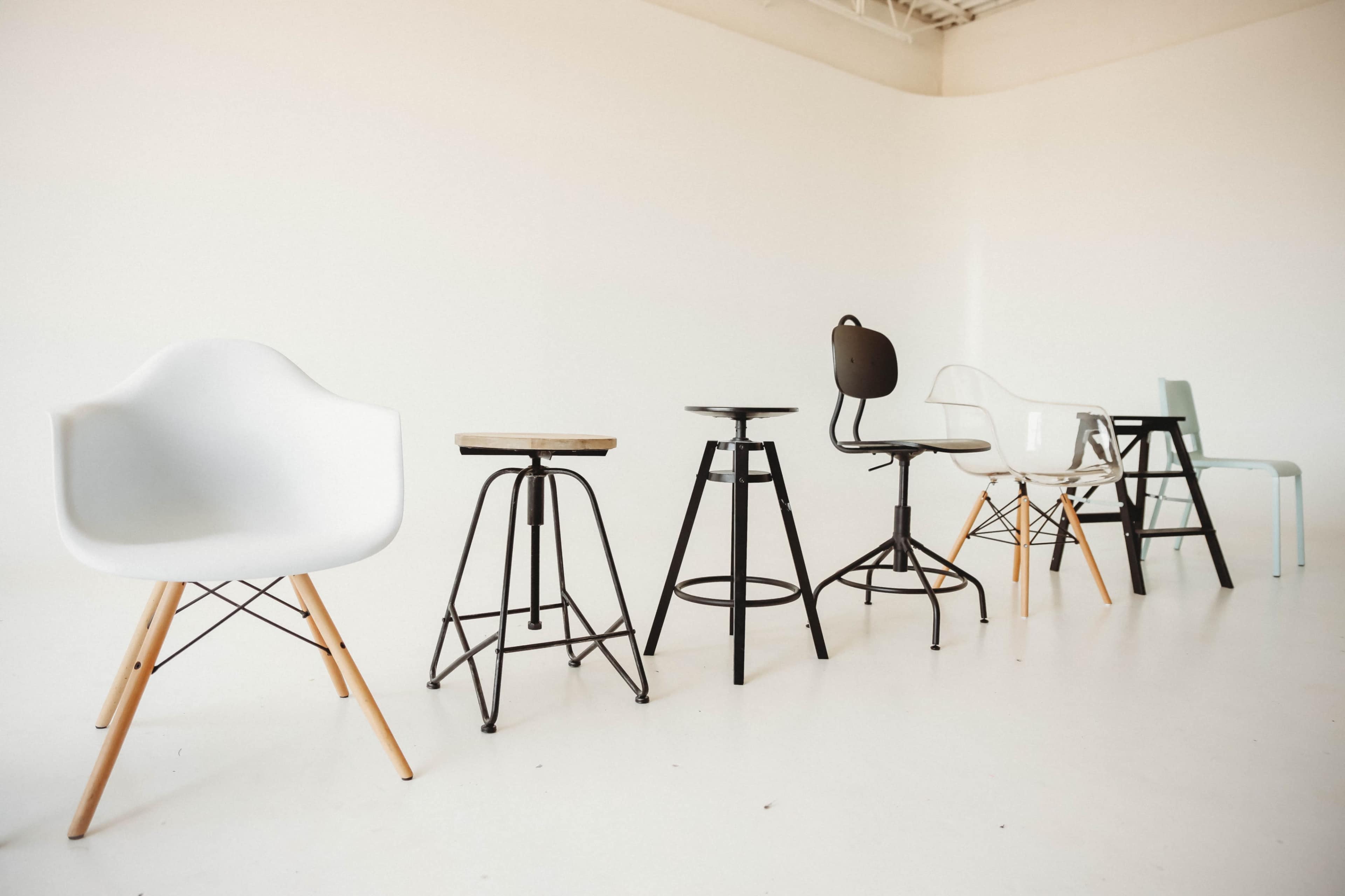 A row of various styles of chairs is displayed against a plain white background.