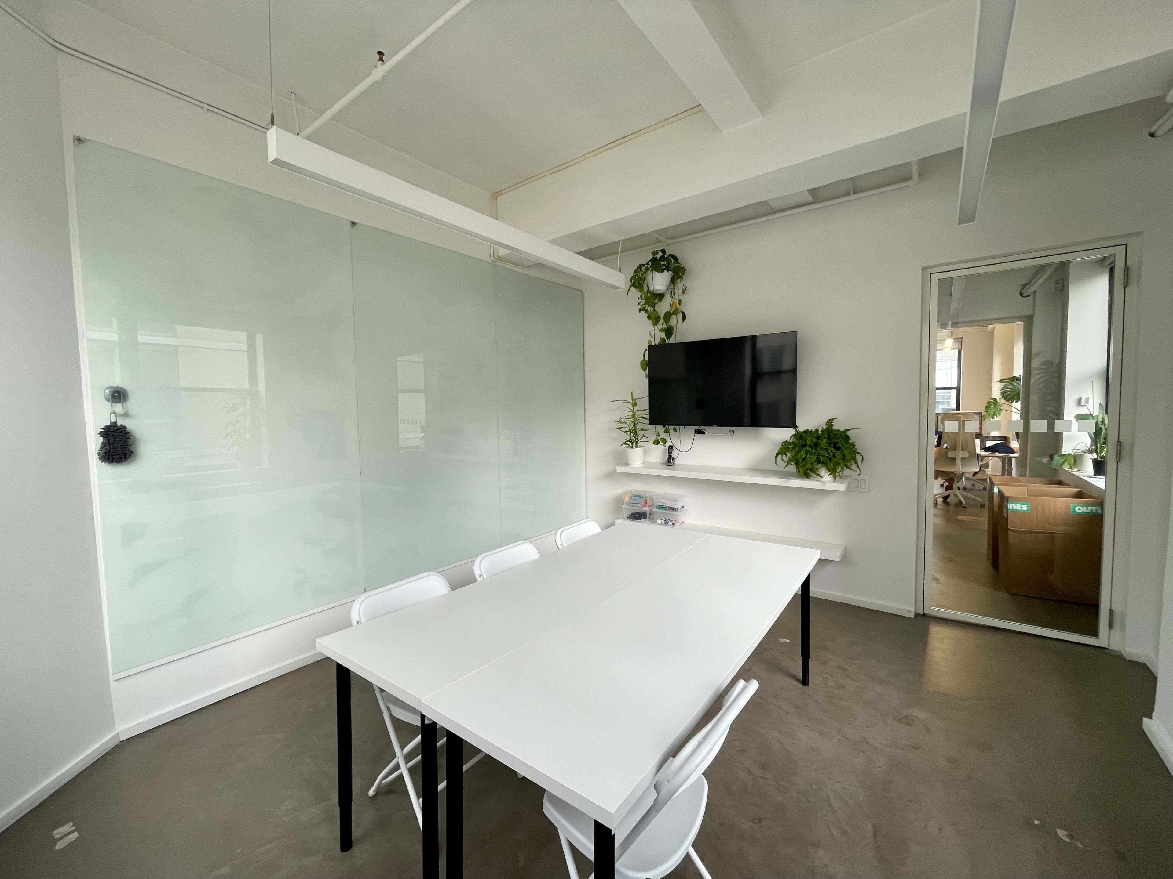 Light filled large meeting room with floor-to-ceiling white boards Image in Midtown Manhattan, New York, NY