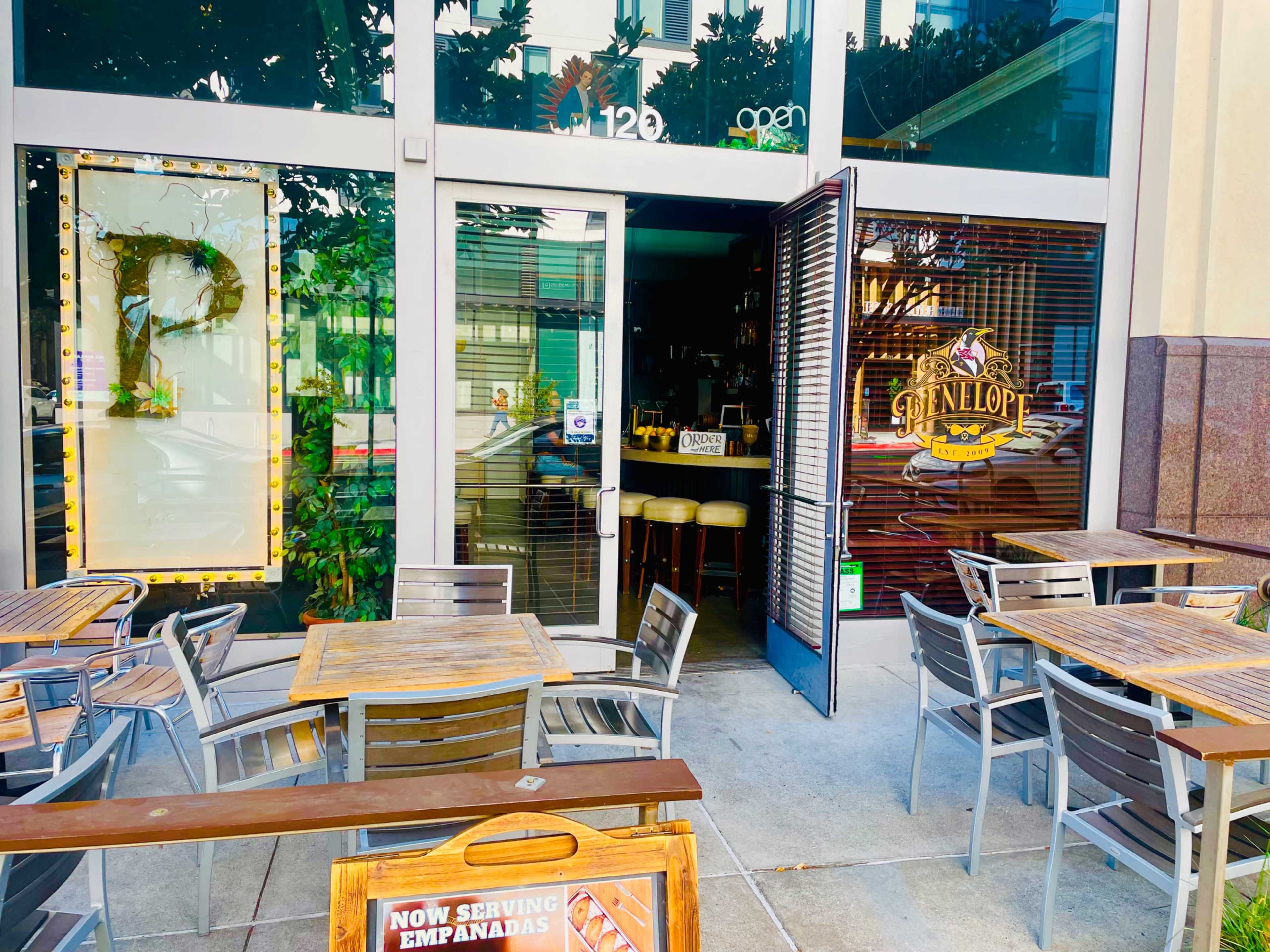 The image shows the entrance of a restaurant called Glenlop, with outdoor tables and chairs arranged in front of the glass doors.