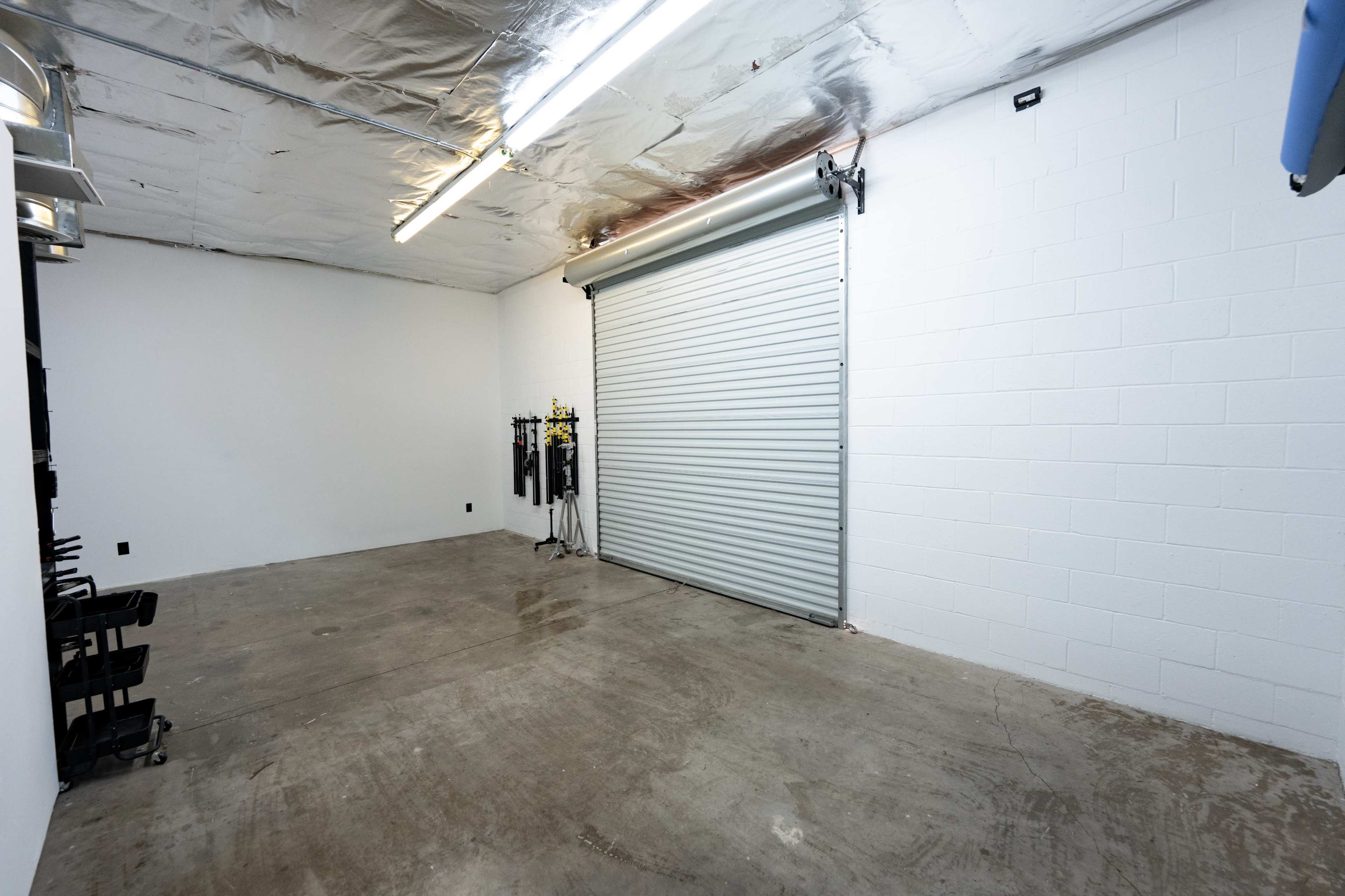 A spacious, empty garage with a concrete floor and a roll-up door on one side.
