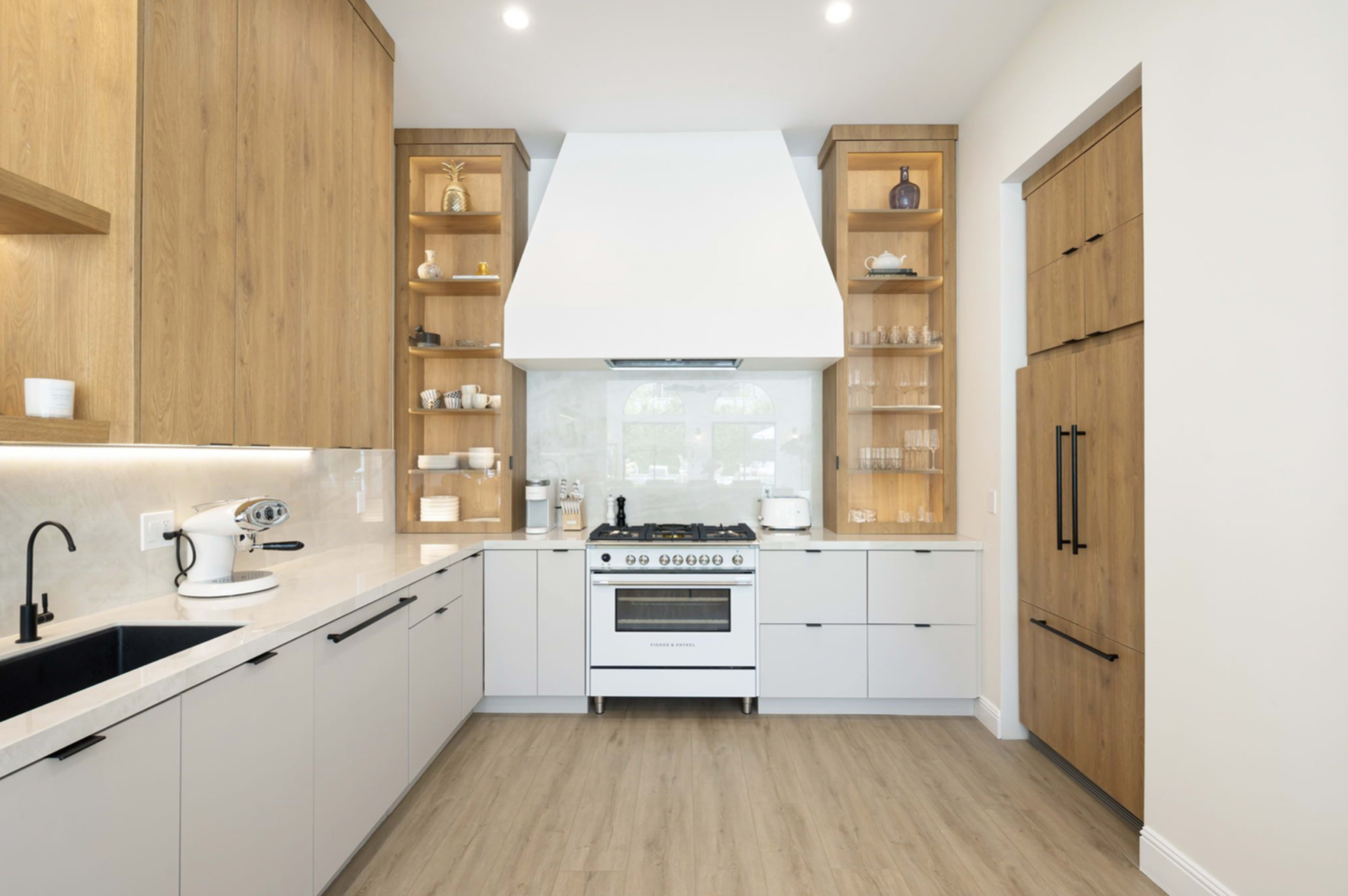 The kitchen features a large central stove with a vent hood, surrounded by wooden shelves and cabinetry in muted colors.