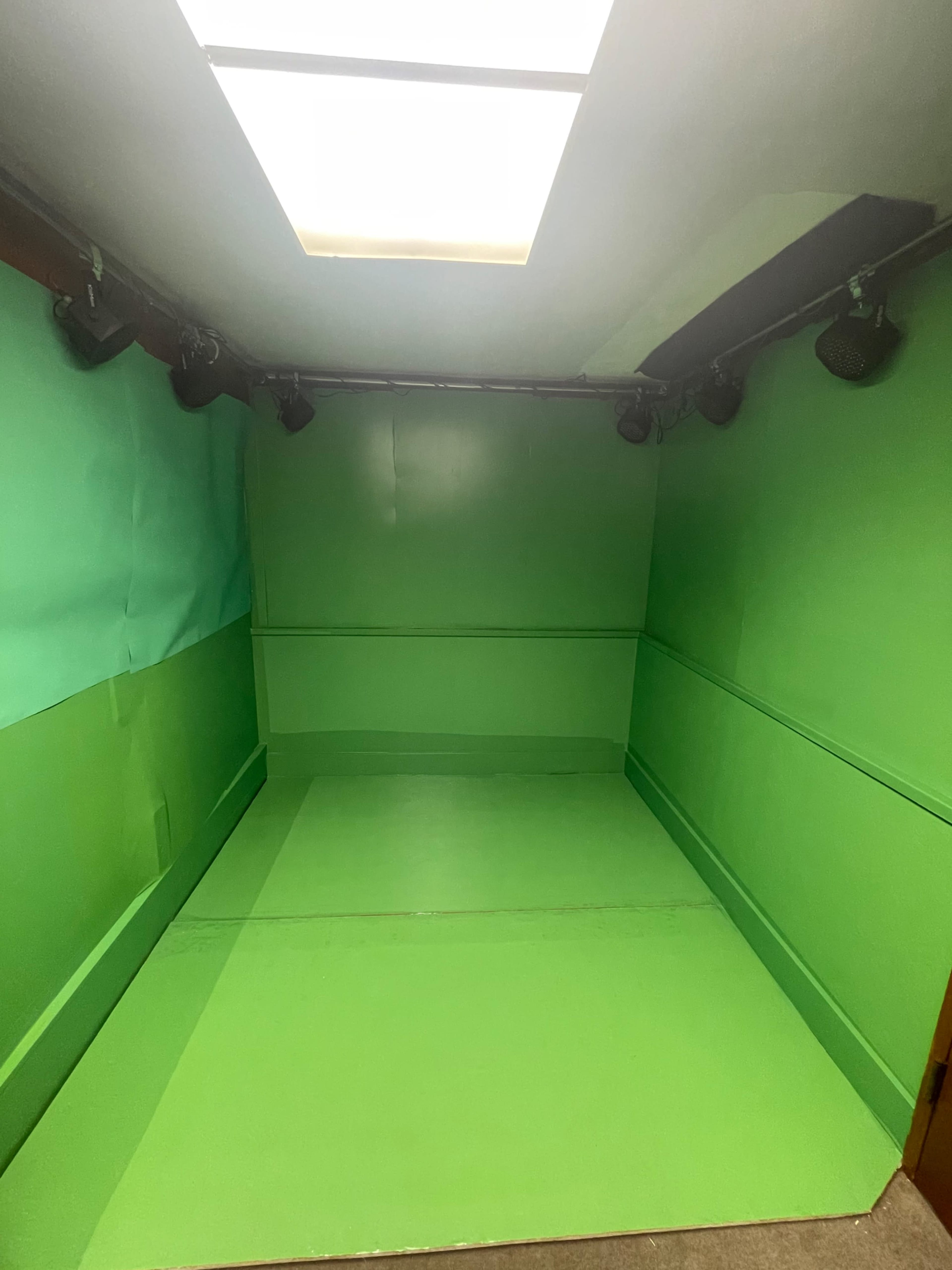 A room with all green walls, floor, and ceiling, designed for chroma keying.