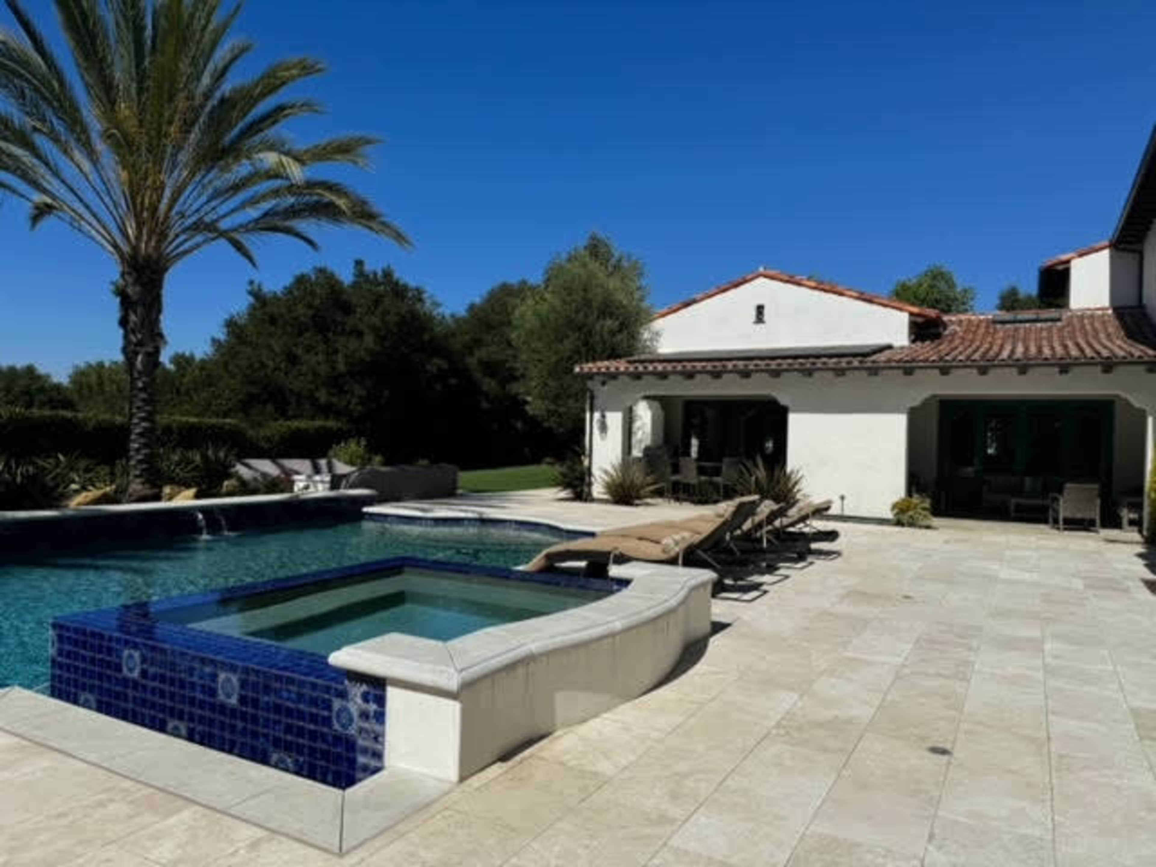 Mediterranean outdoor space with separate garden courtyard and backyard with a pool and spa.  It is surrounded by pal trees, olive trees, fruit trees, cypress trees.  Expansive and open back yard with endless views. Image in Turtle Rock, IRVINE, CA