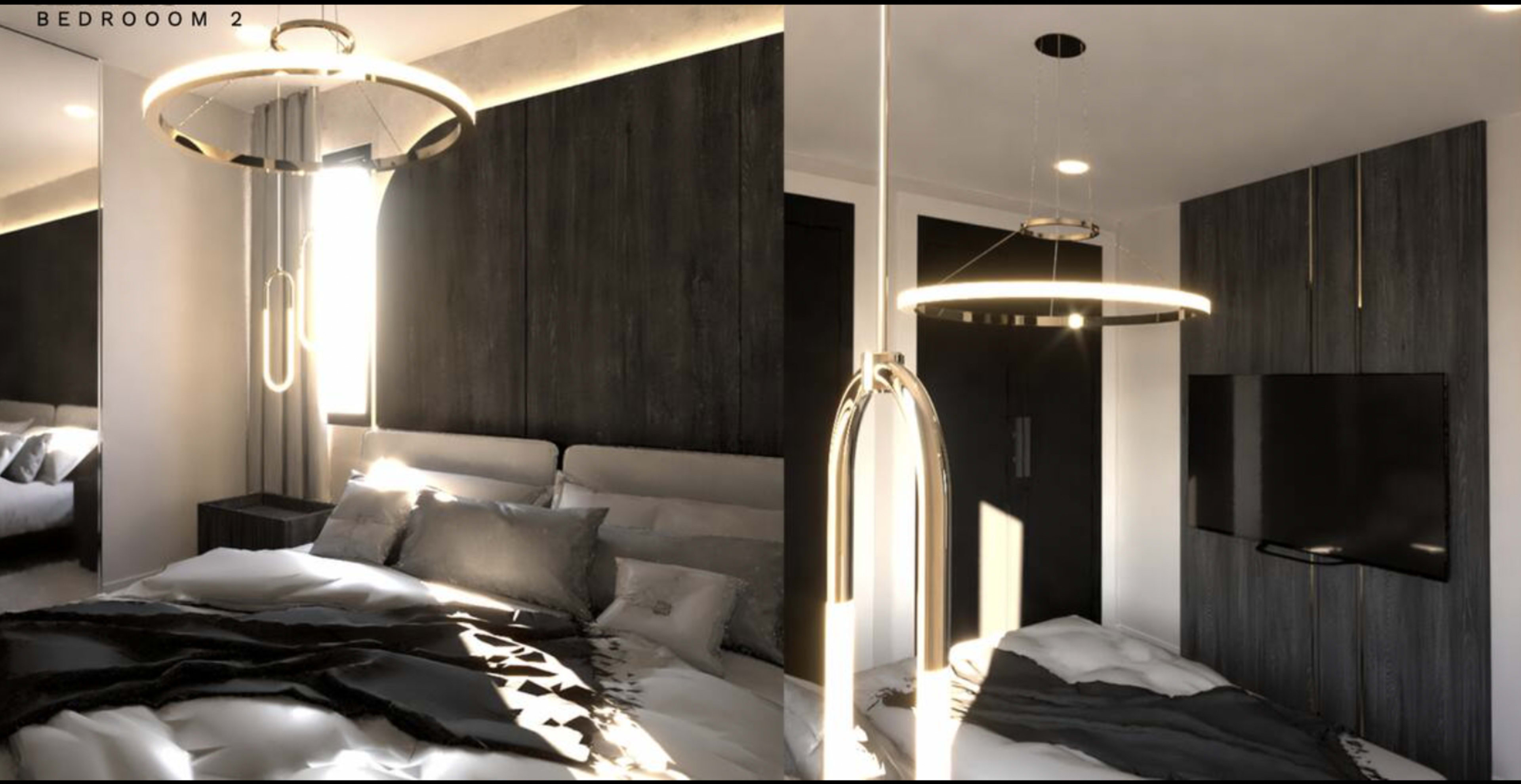 The image shows a modern bedroom featuring a hanging light fixture, a bed with gray bedding, and a wall-mounted television.