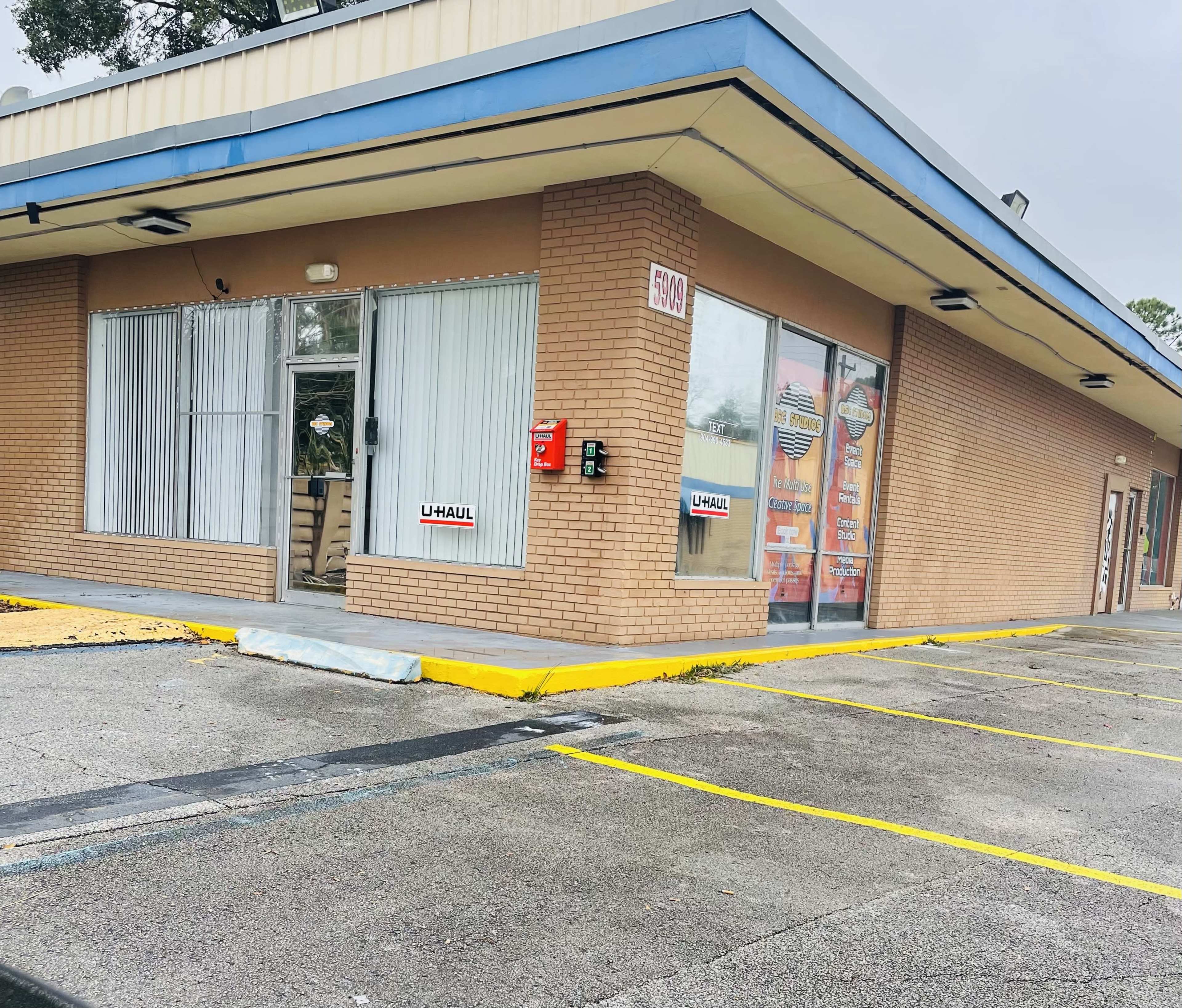 The exterior of a U-Haul rental location in a single-story commercial building with large windows and a parking area.