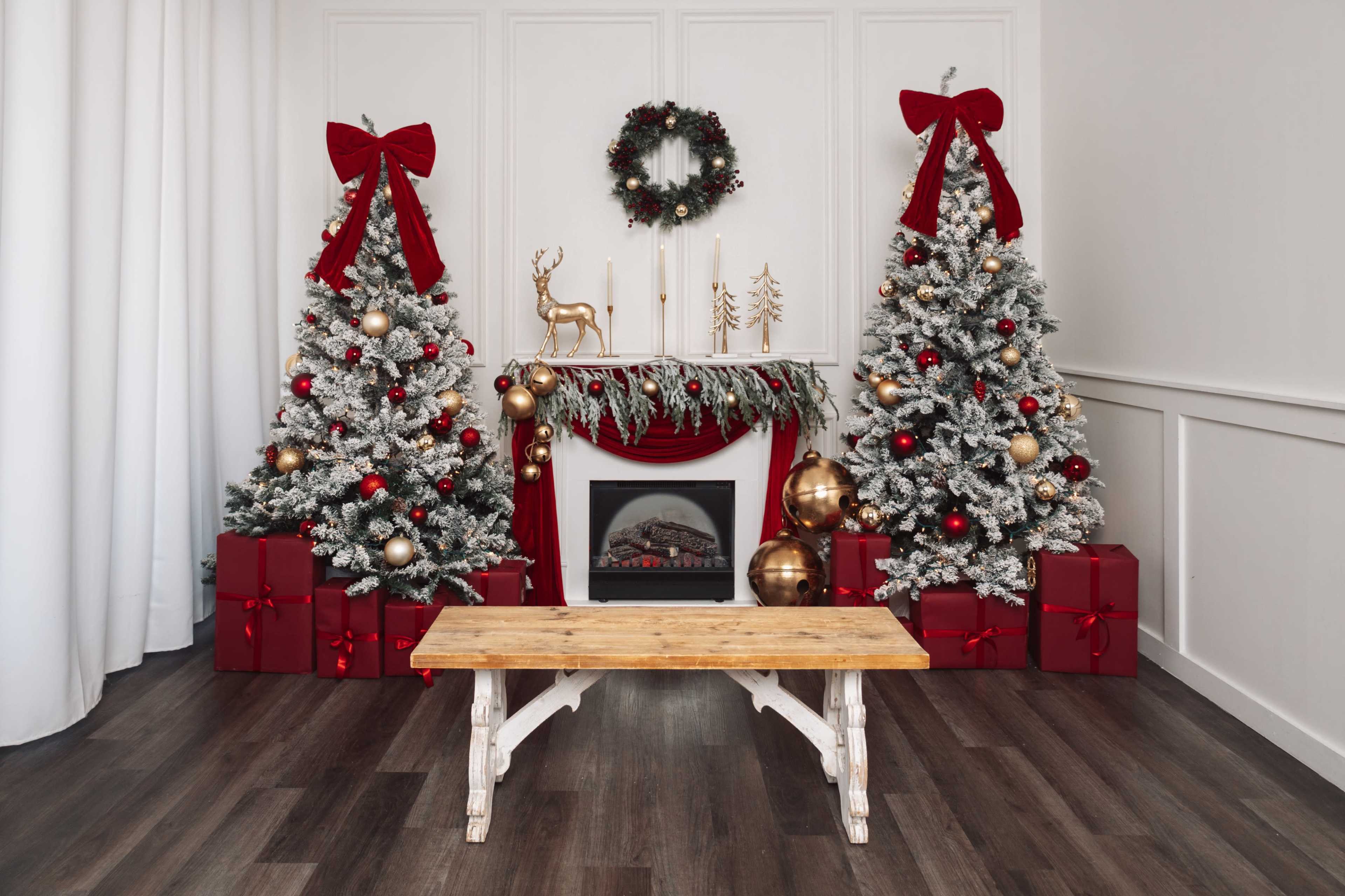 The scene features a festive living room with two decorated Christmas trees, a fireplace, and a wooden table in the center, surrounded by red gift boxes.