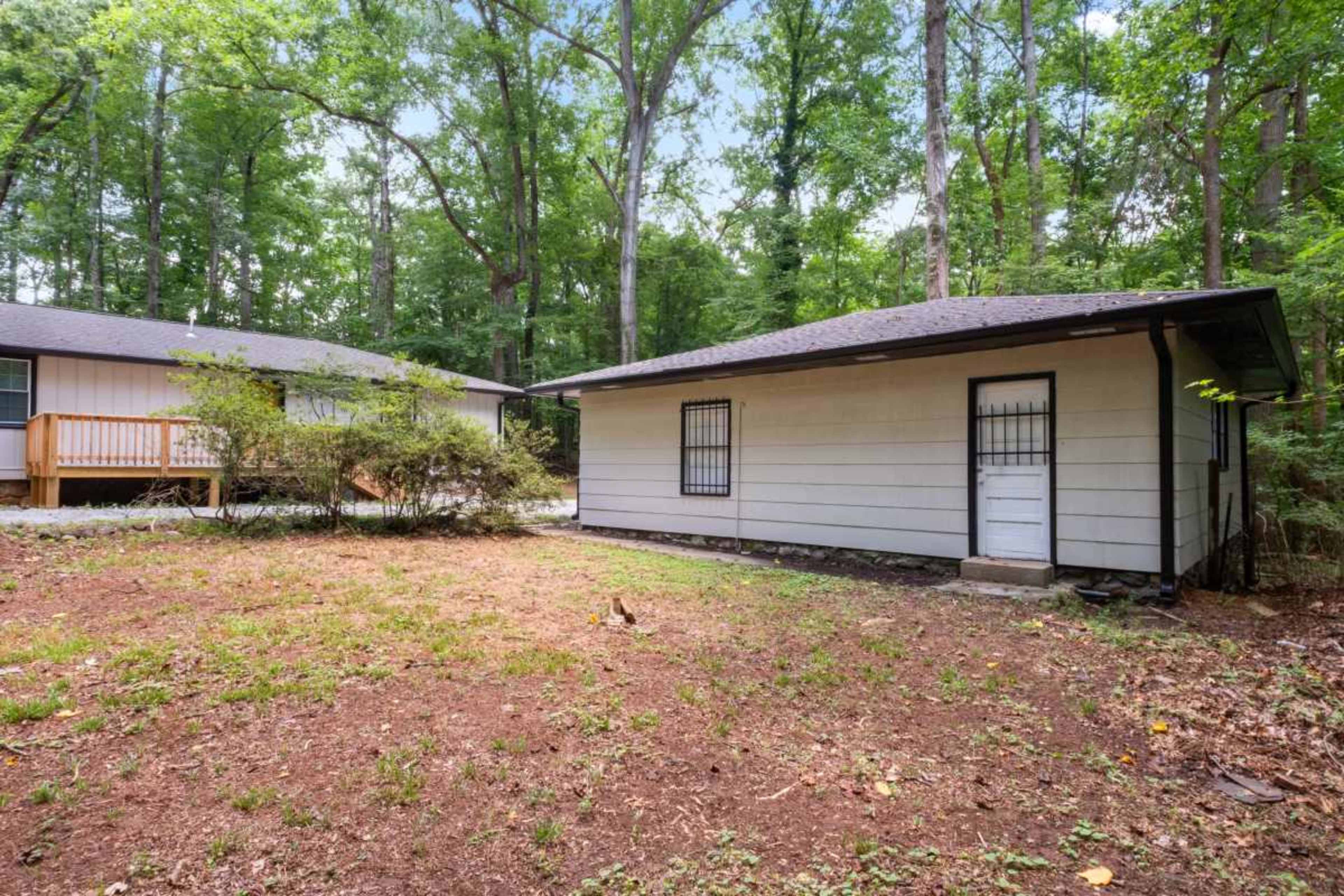The image shows two single-story buildings surrounded by trees in a forested area.