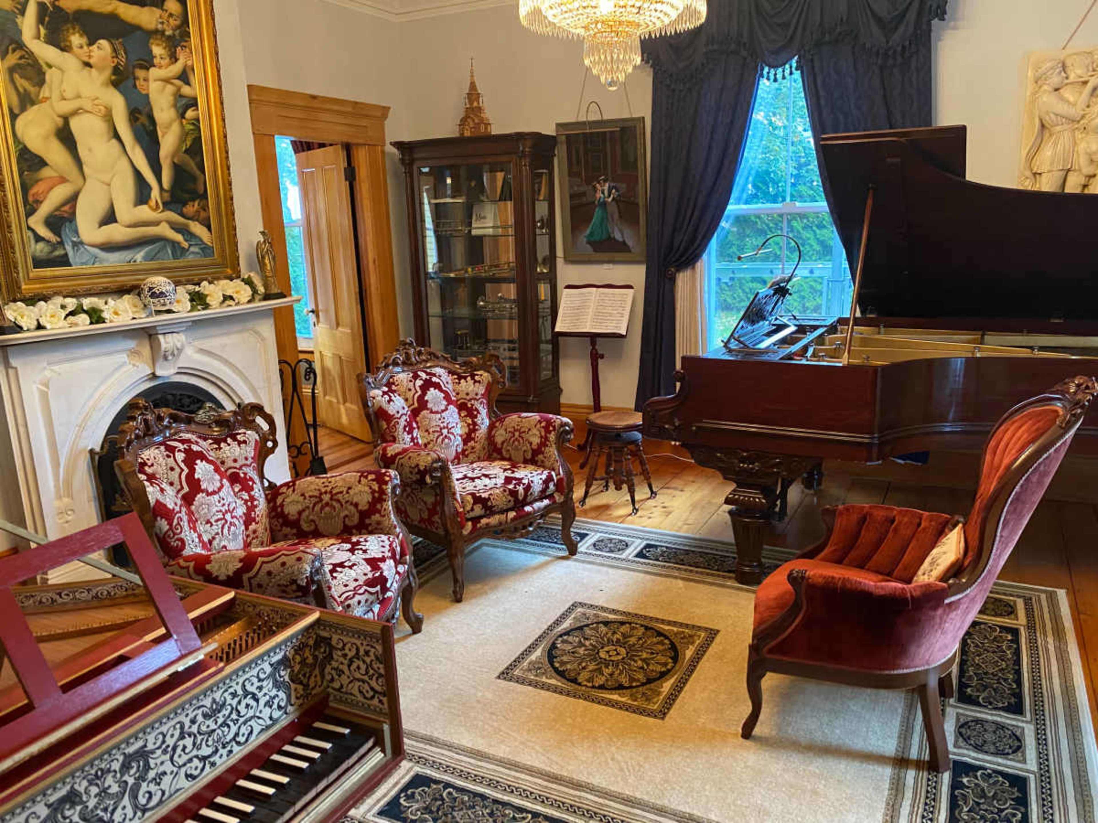 The room features an ornate grand piano, vintage furniture, and a large painting on the wall, creating a classic musical setting.
