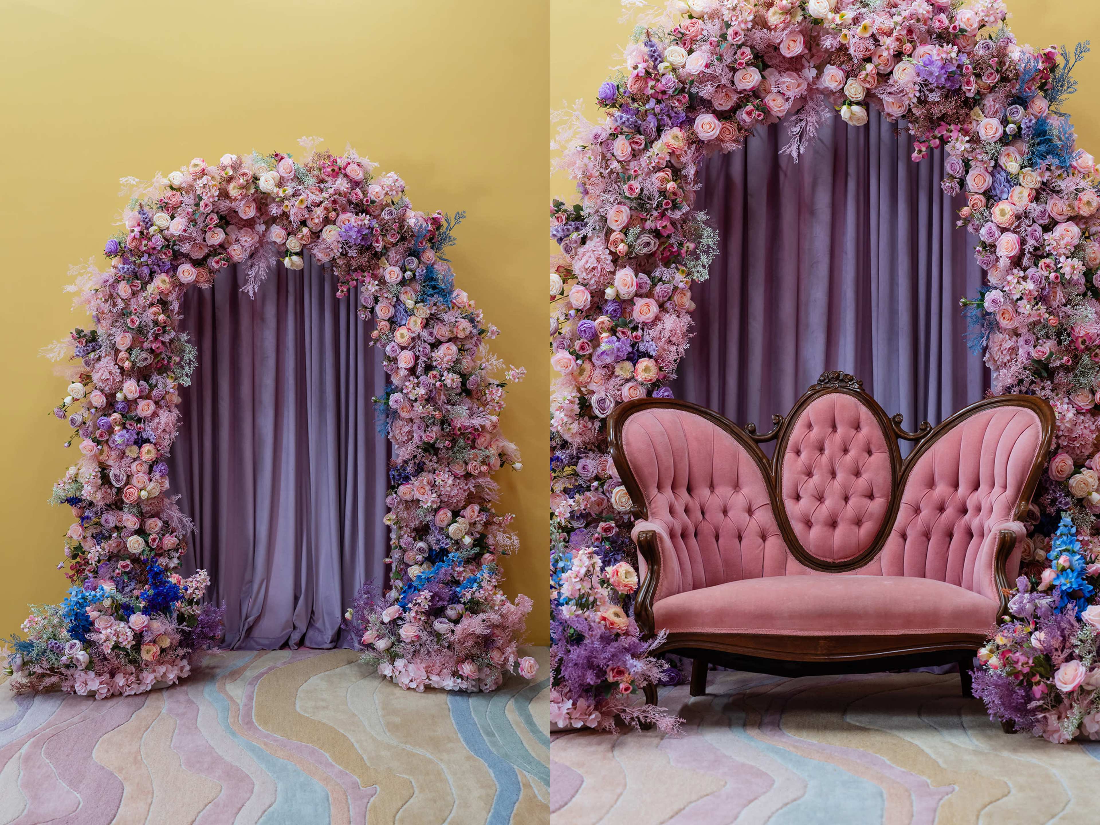 The image features a floral arch adorned with pink and purple flowers surrounding a curtained doorway, beside a vintage pink upholstered sofa set against a textured pastel rug.