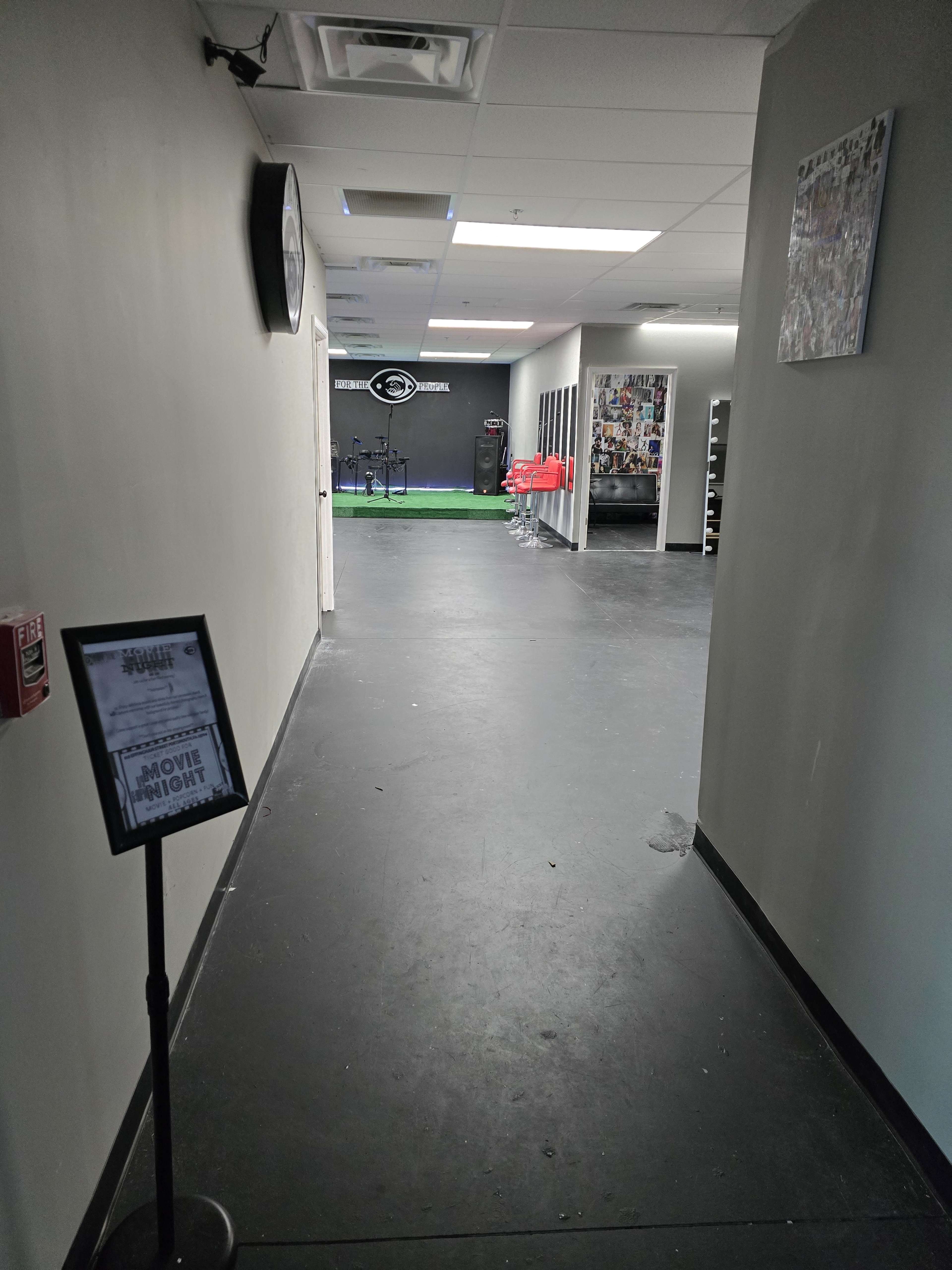 A hallway leading to a gym area with exercise equipment visible at the far end.