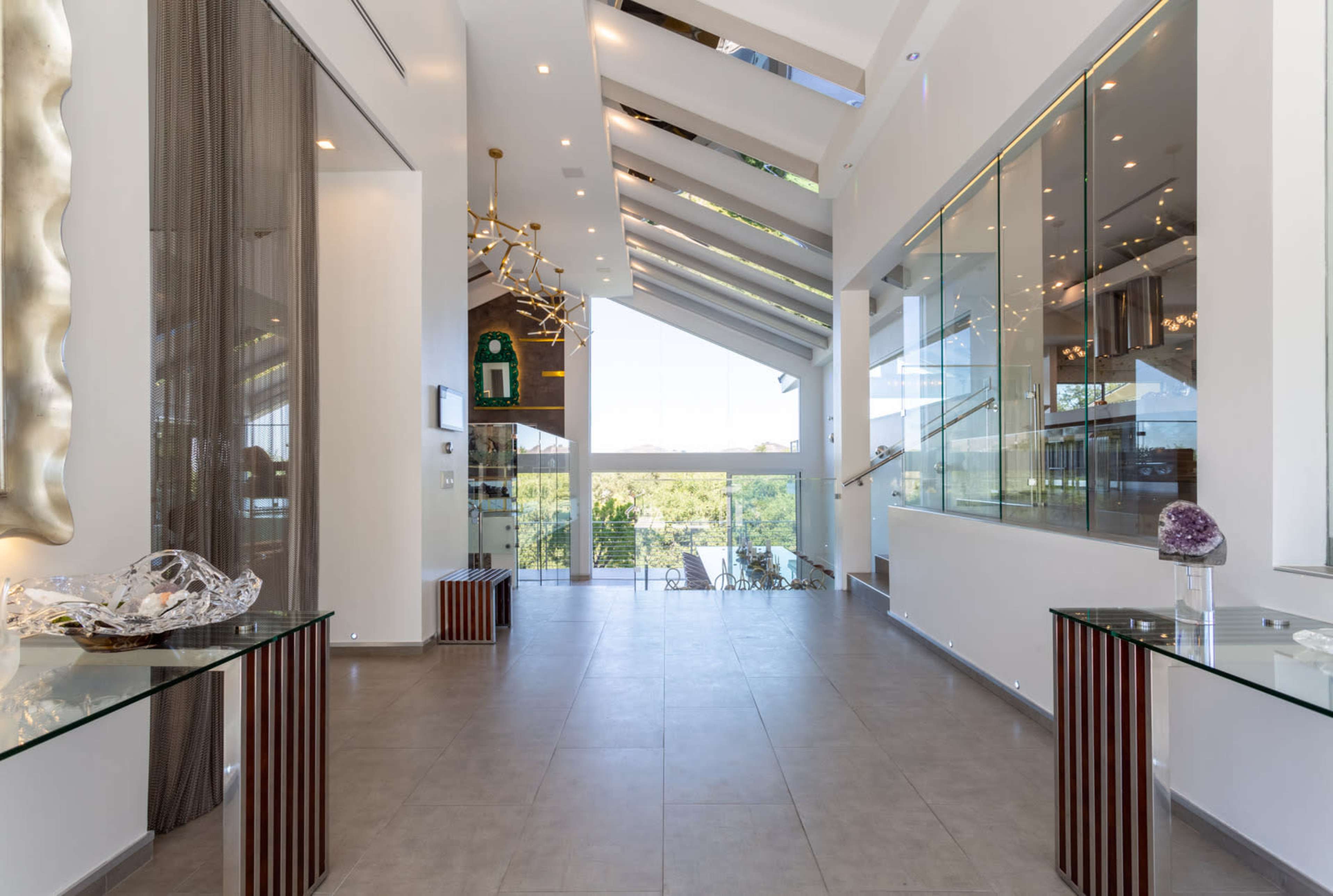 A modern interior space with high ceilings, large windows, and contemporary furniture along the walls.
