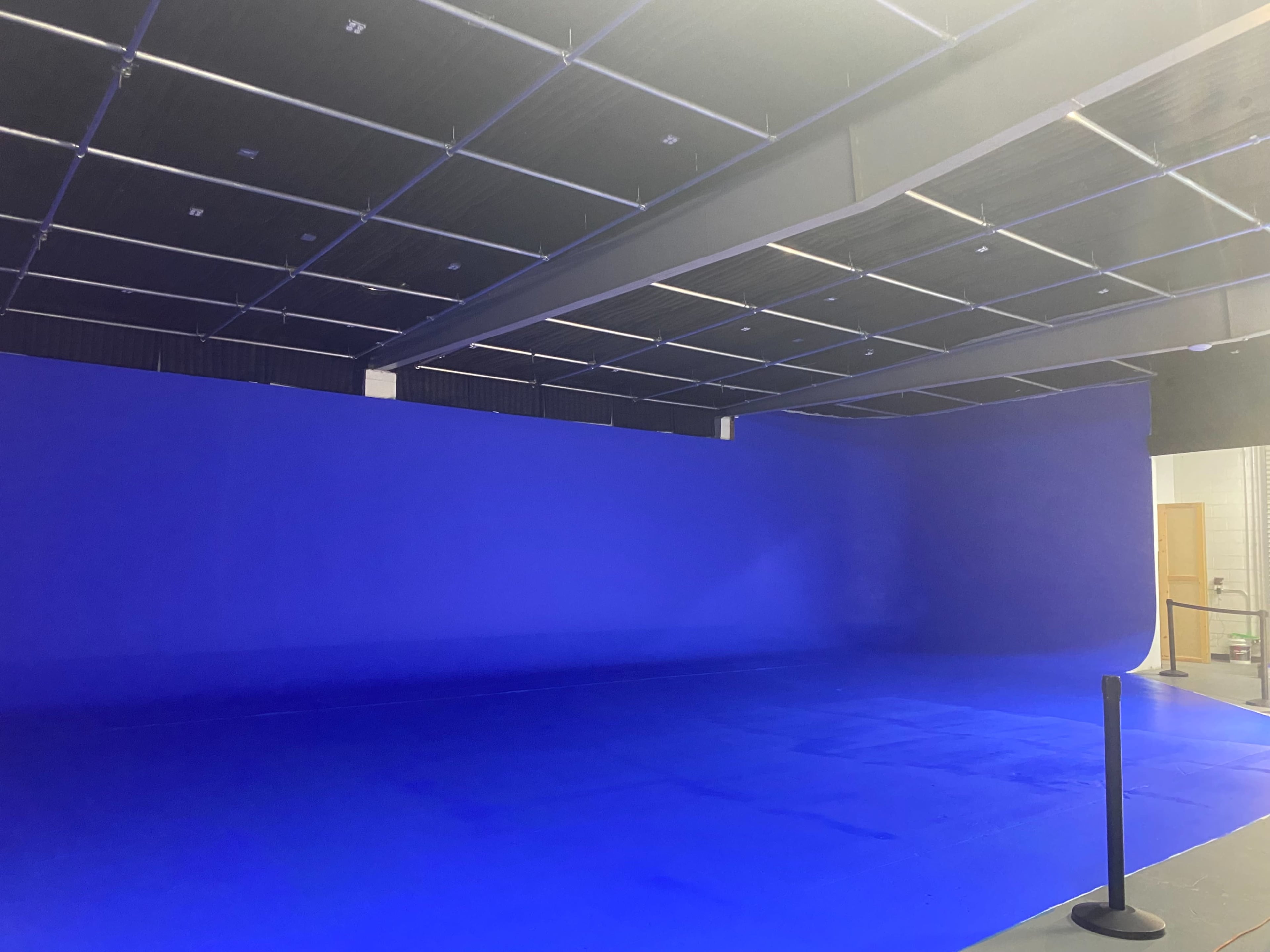 A spacious studio with a large blue backdrop and a smooth blue floor.