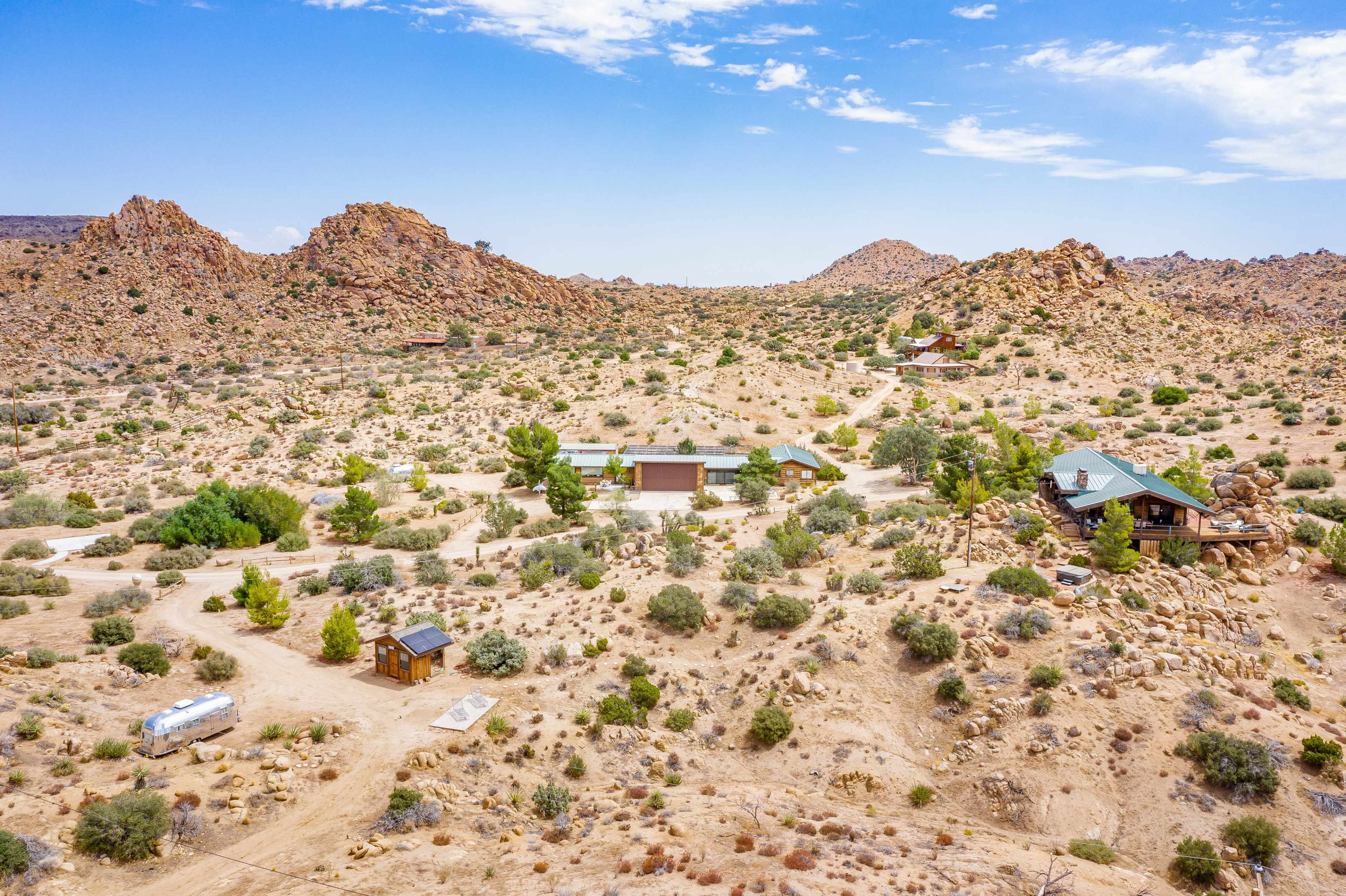 A desert landscape with scattered rocky formations and a few buildings integrated into the terrain.