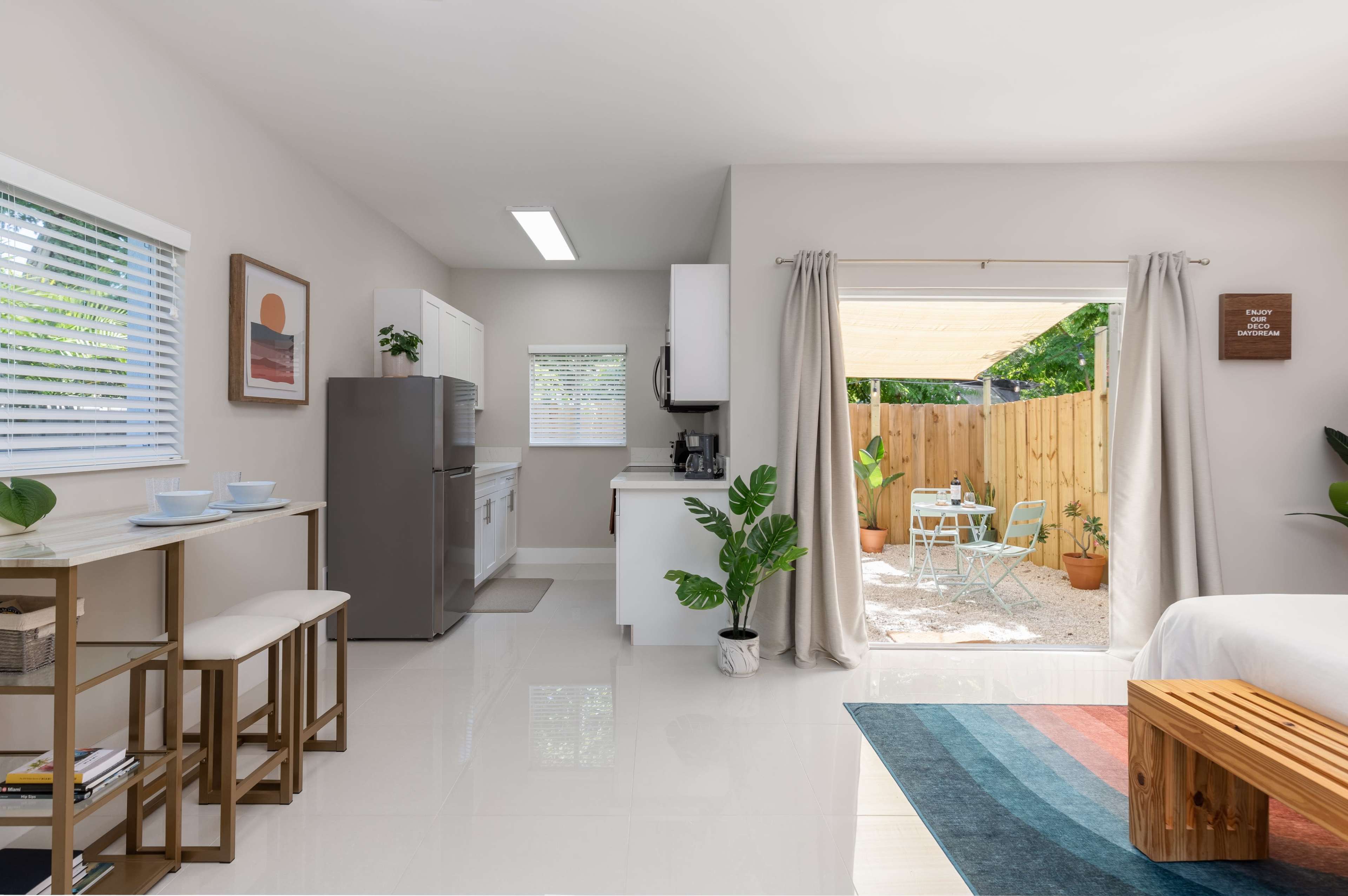 A modern open-concept kitchen and living area leads to a private patio with outdoor seating.