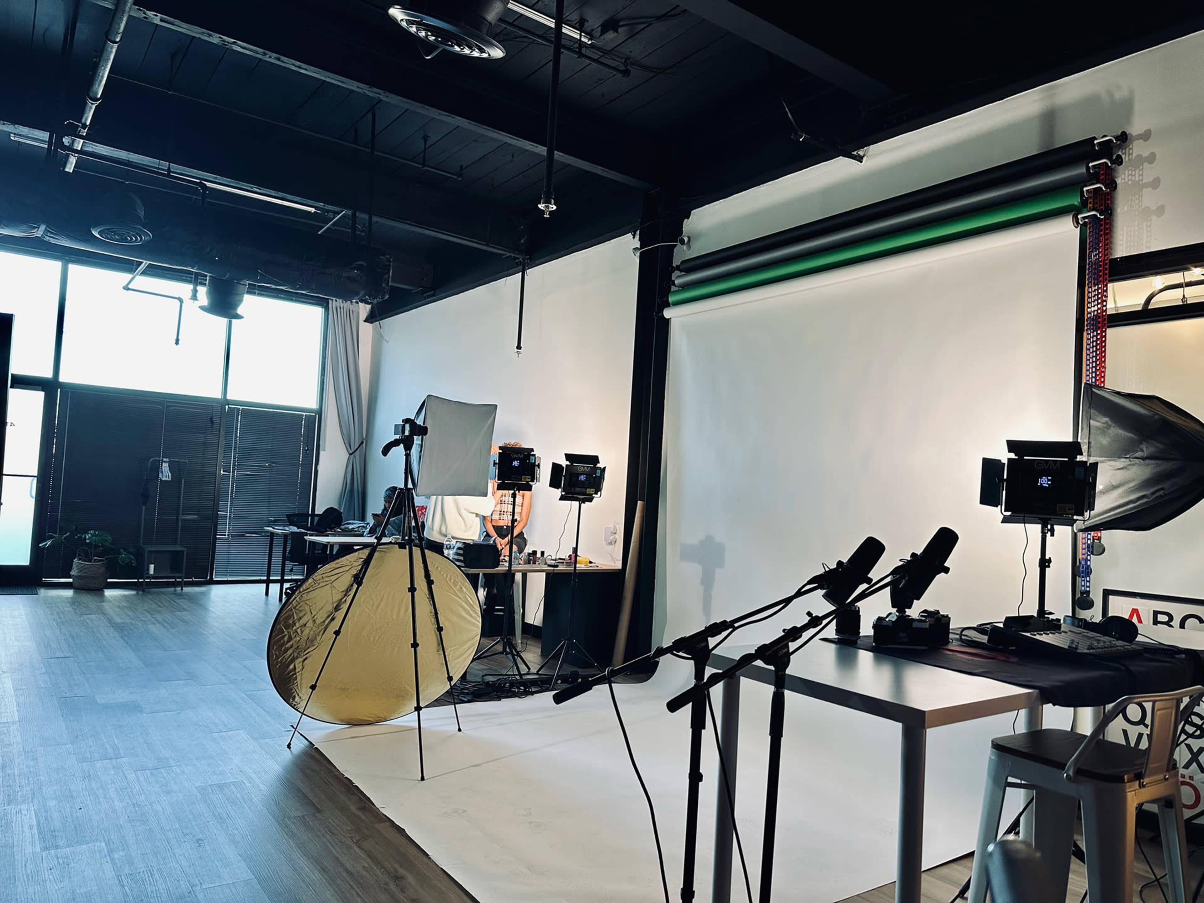 A photography studio with lighting equipment, a backdrop, and tables arranged for a shoot.