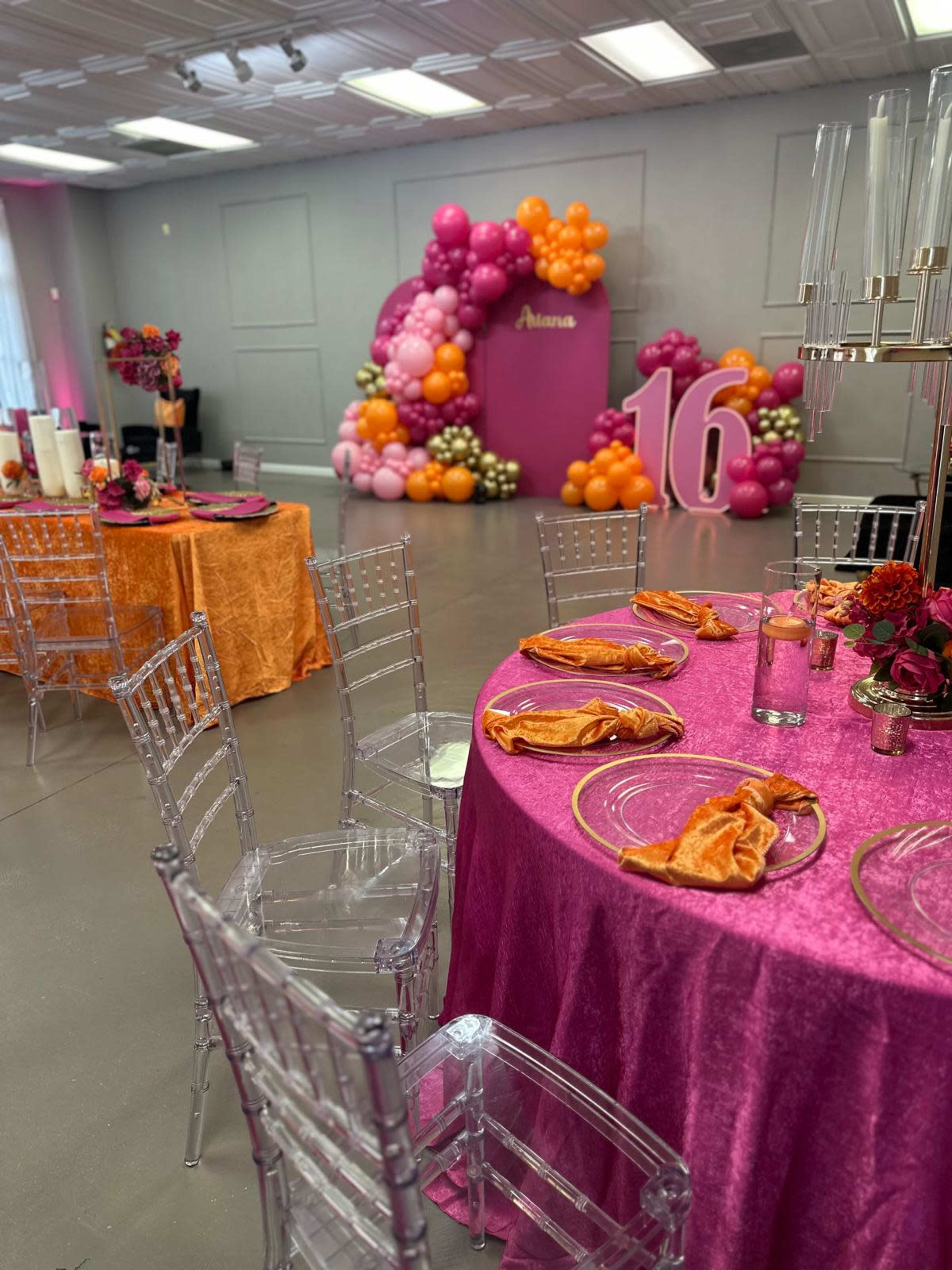The image shows a festive event space decorated with colorful balloons, elegant tables set with vibrant linens and tableware, and a prominent display celebrating a 16th birthday.