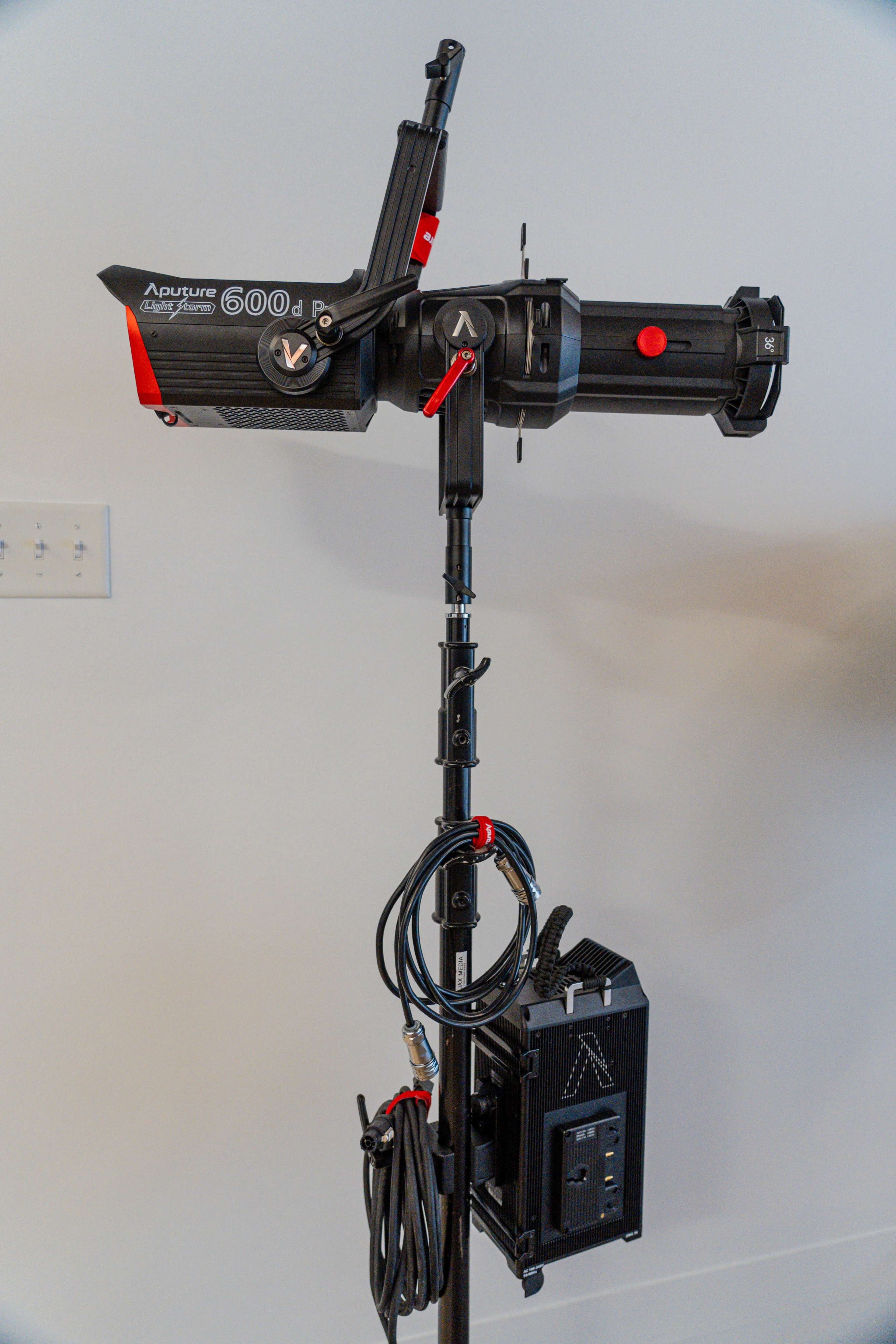 An Aputure 600d Pro LED light mounted on a sturdy stand, with cables neatly organized and a power control box attached.