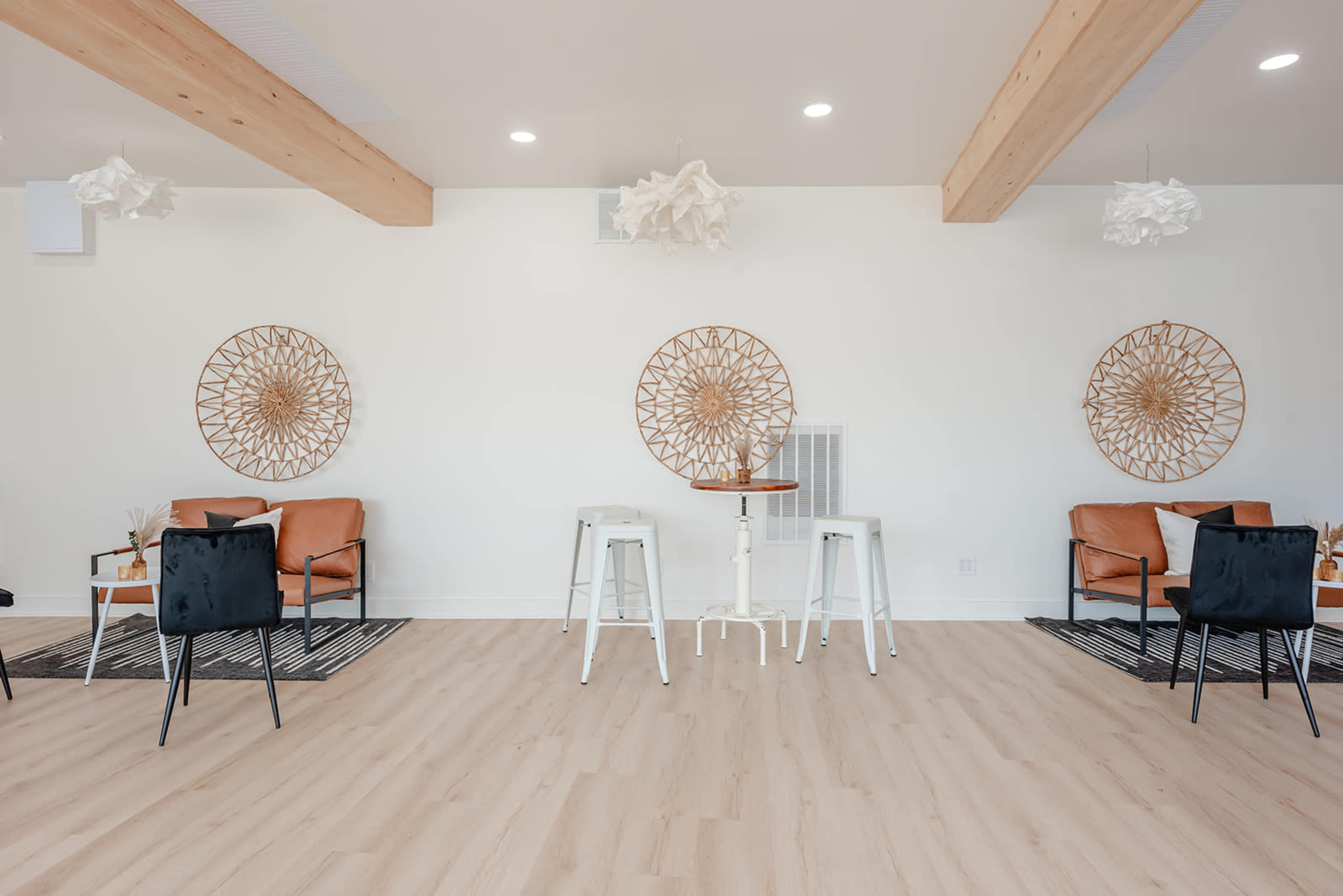 A modern, minimalist cafe interior featuring light wood beams, stylish seating, and decorative wall art.