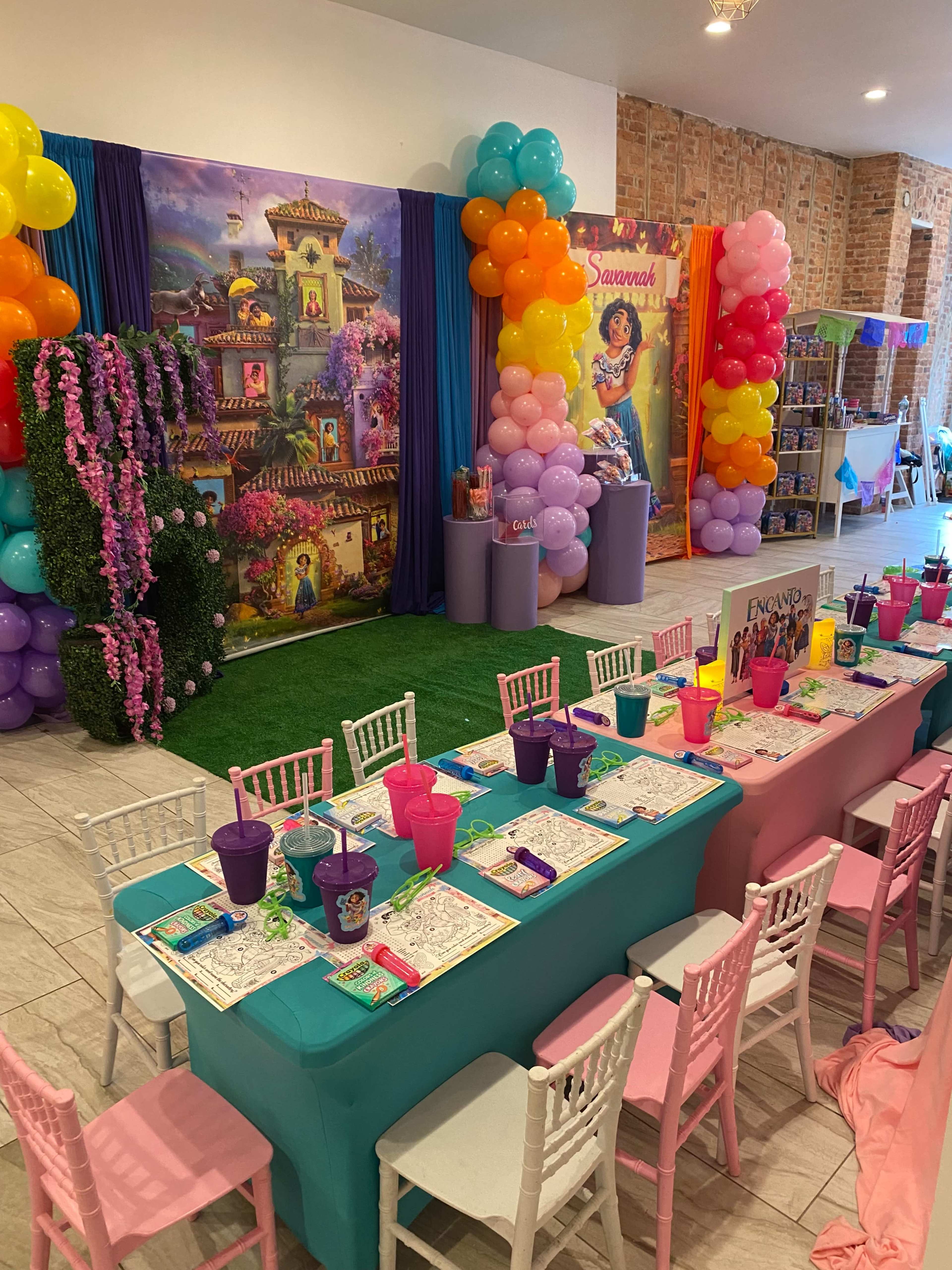 A decorated event space with a vibrant table setup, colorful balloons, and themed decorations for a celebration.