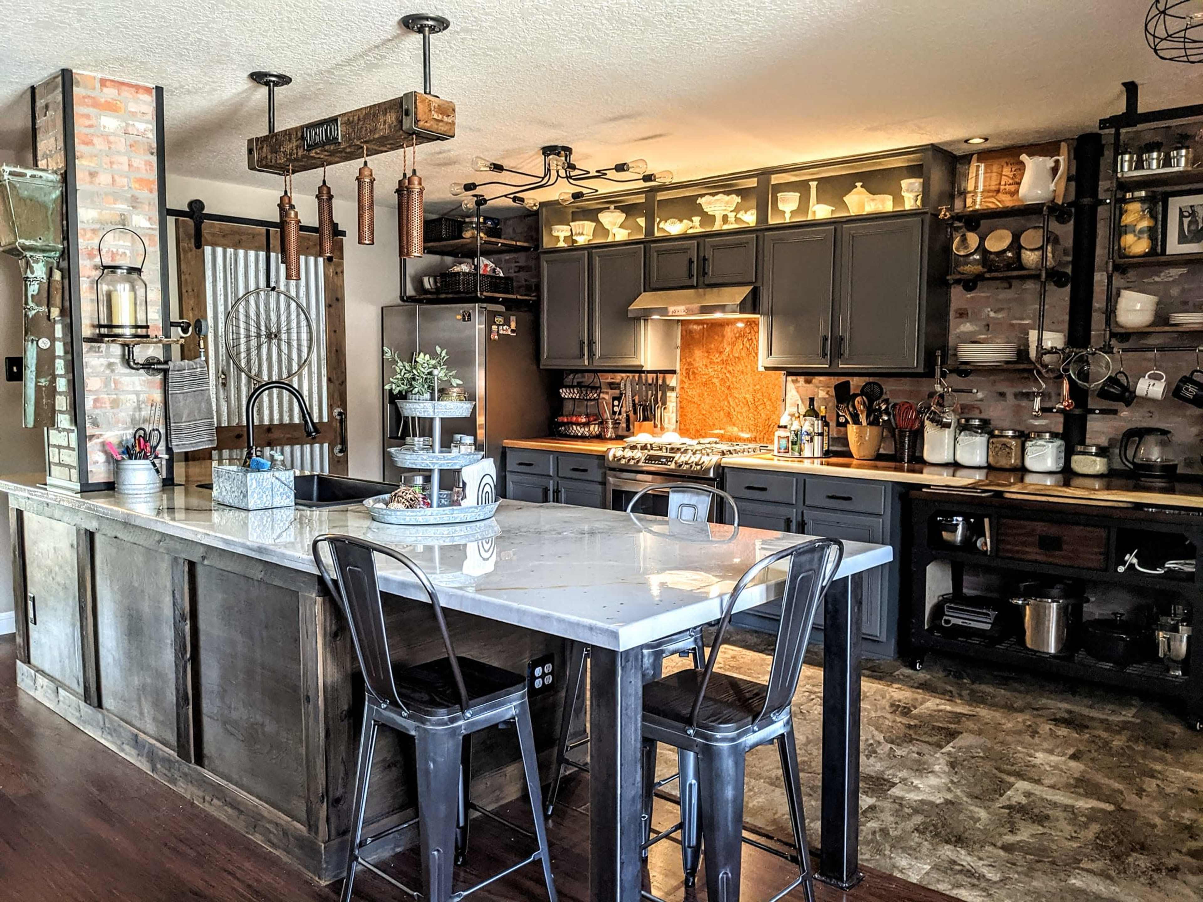 A spacious kitchen features a central island with bar stools, dark cabinetry, and an arrangement of shelves displaying various kitchen items.