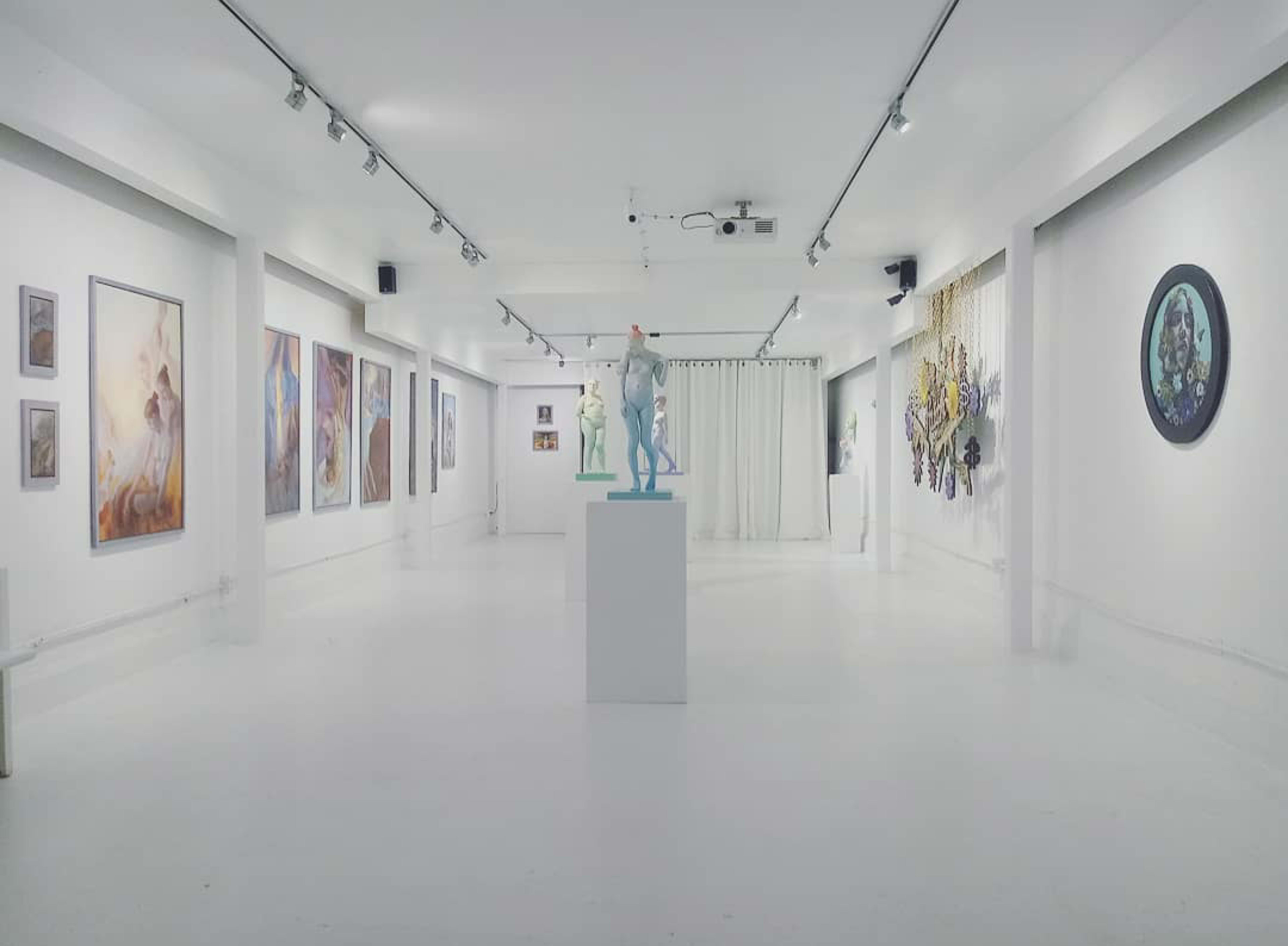An art gallery with white walls displaying various paintings and sculptures, including a central figure on a pedestal.