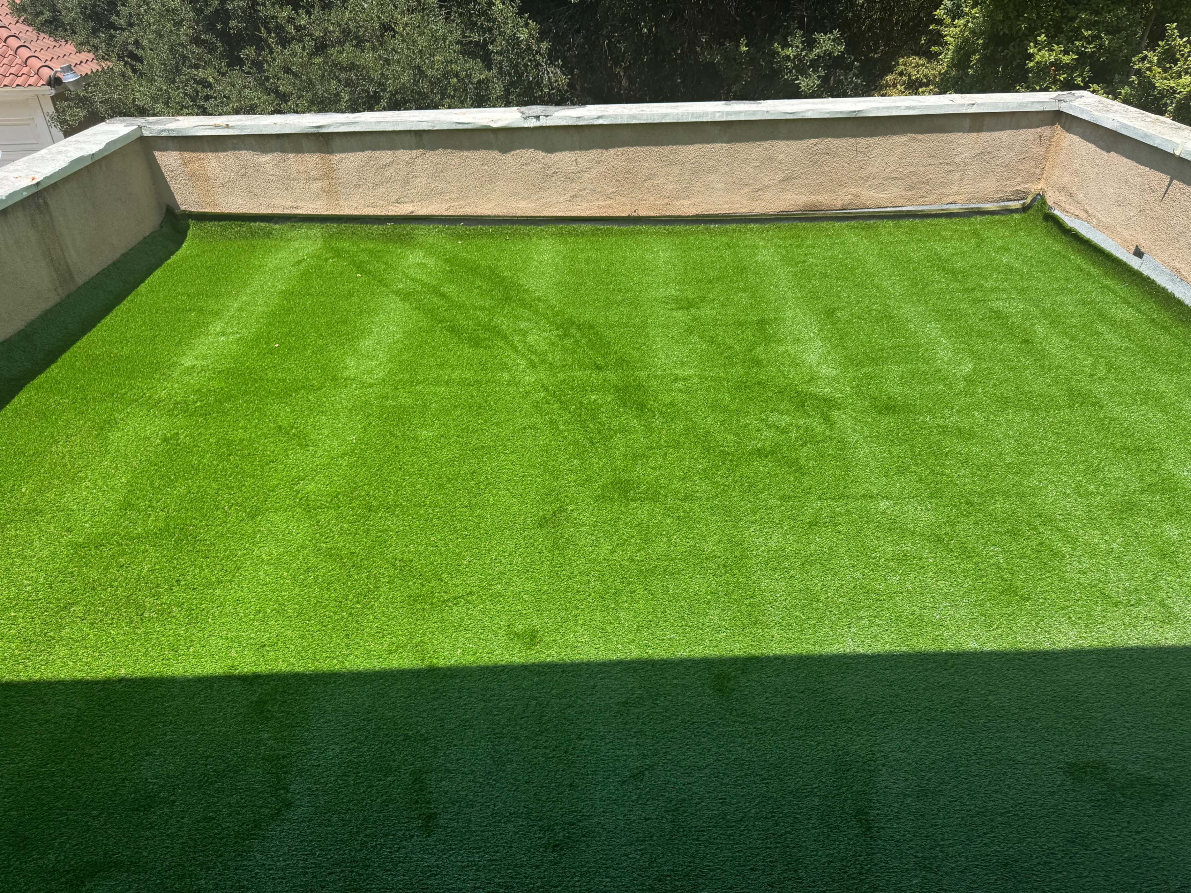 The image shows a flat rooftop covered with bright green artificial grass.