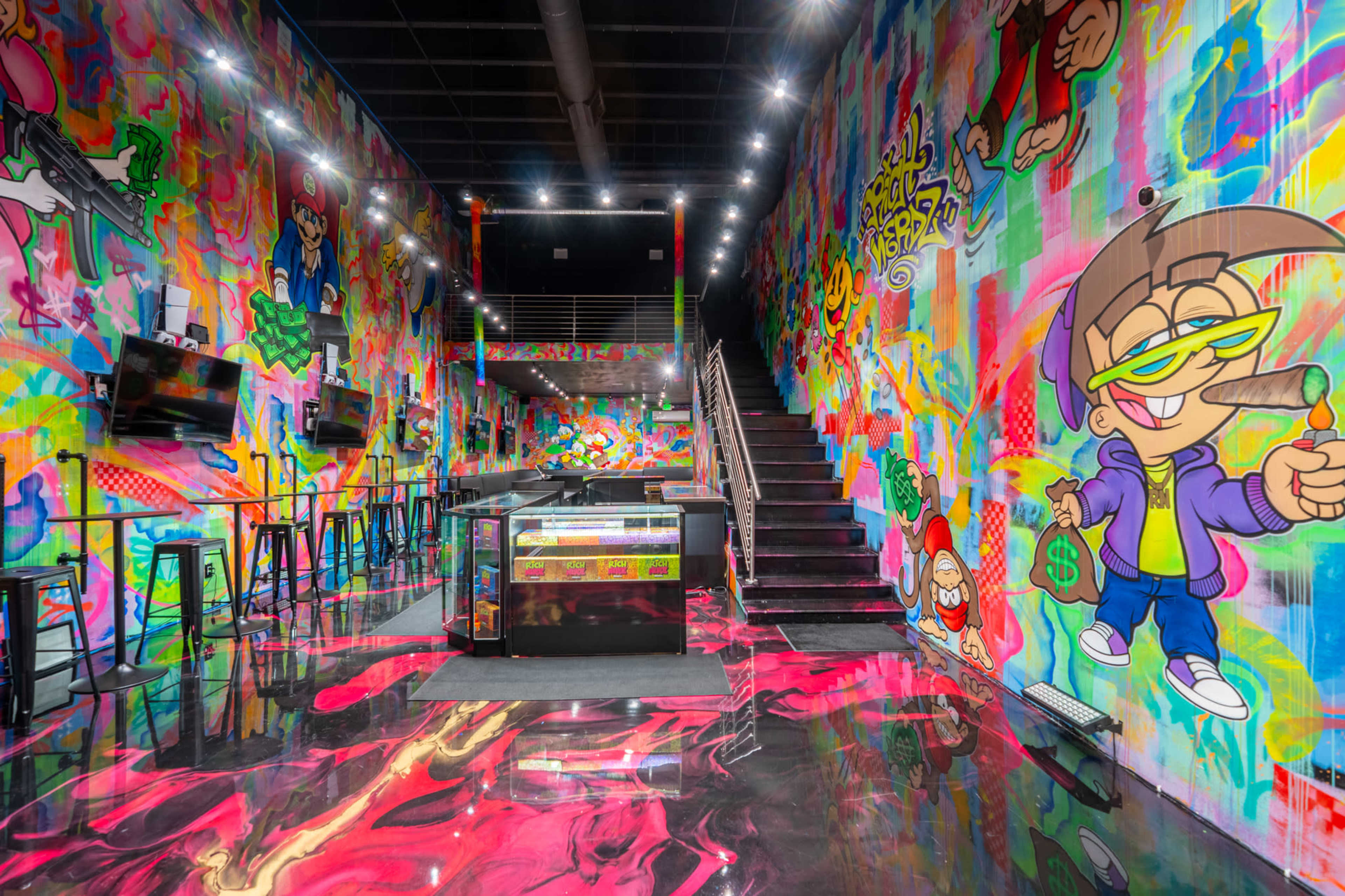 The image depicts a vibrant, graffiti-covered room with colorful walls, a shiny floor, and a staircase in the background.