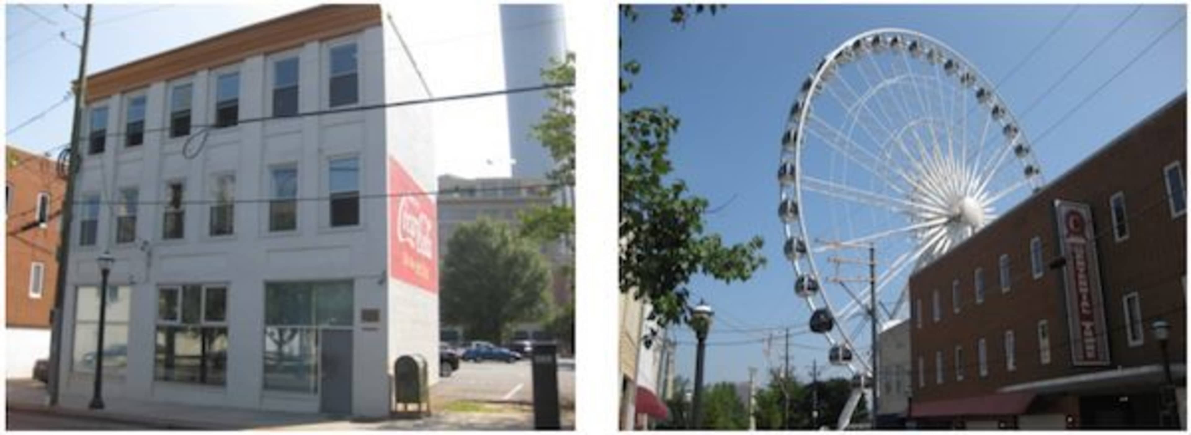 A two-story building with a sign on the side and a large Ferris wheel in the background under a clear blue sky.