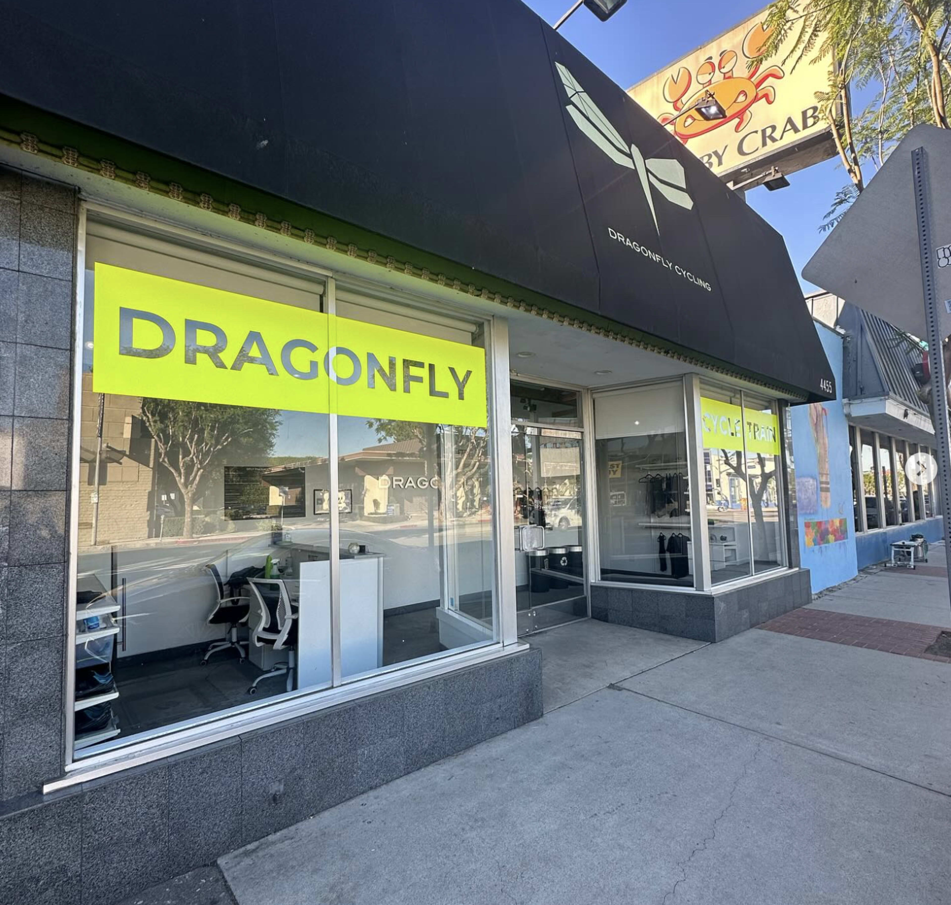 The storefront features a large, bright yellow sign reading "DRAGONFLY" above a glass entryway.
