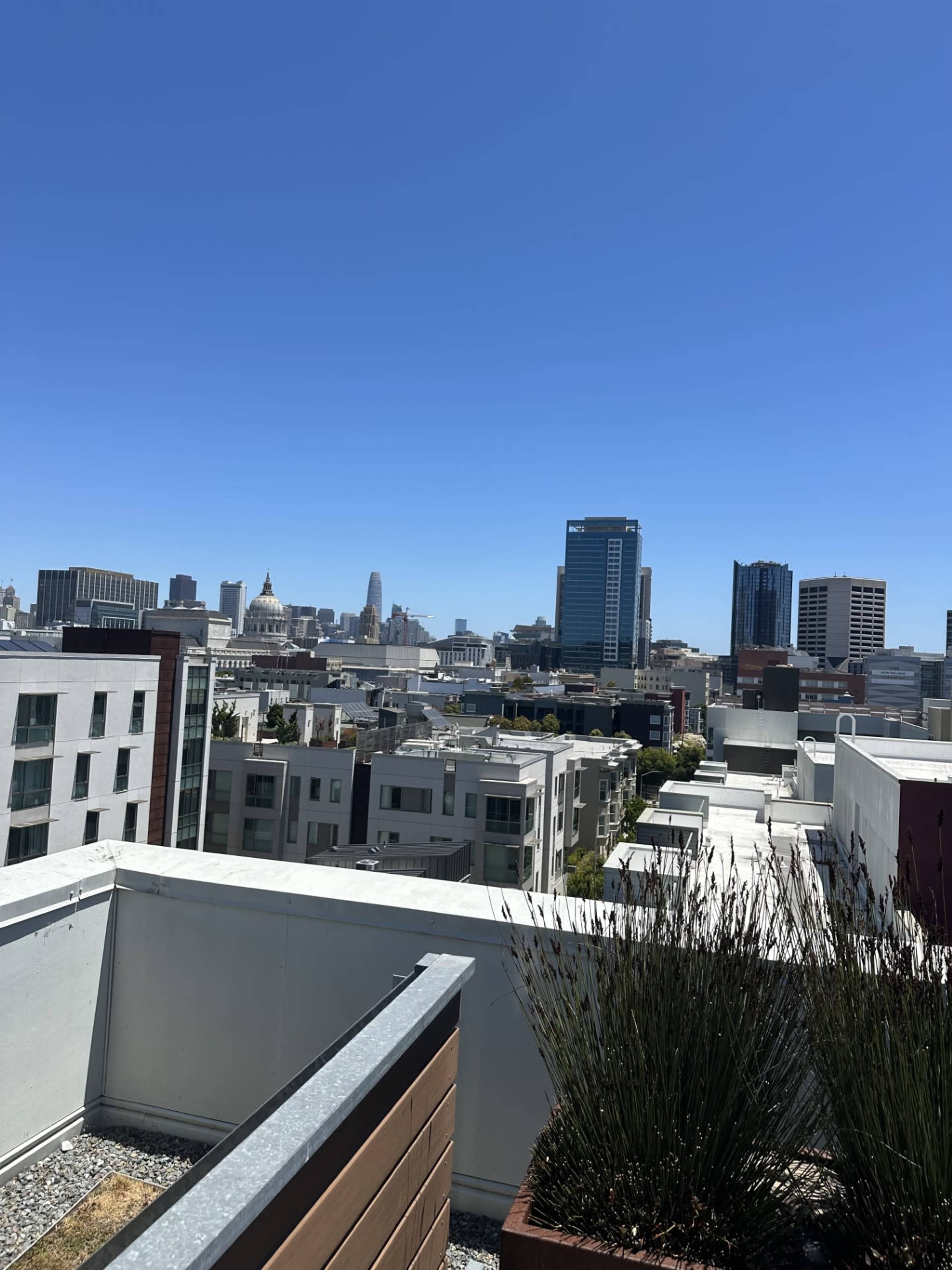 A view of a city skyline, with modern buildings and a clear blue sky.