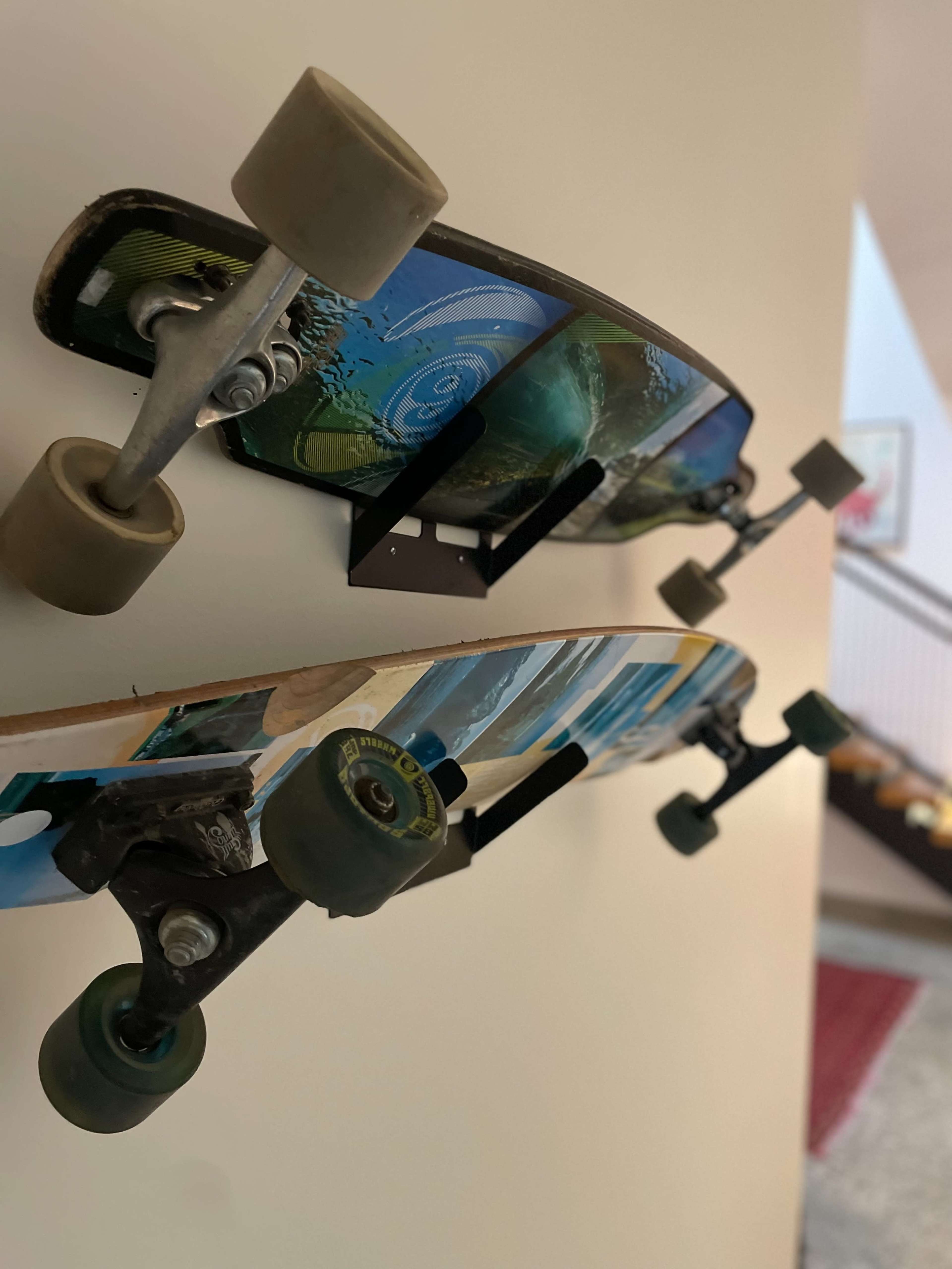 Two skateboards are mounted vertically on a wall, showcasing their wheels and trucks.