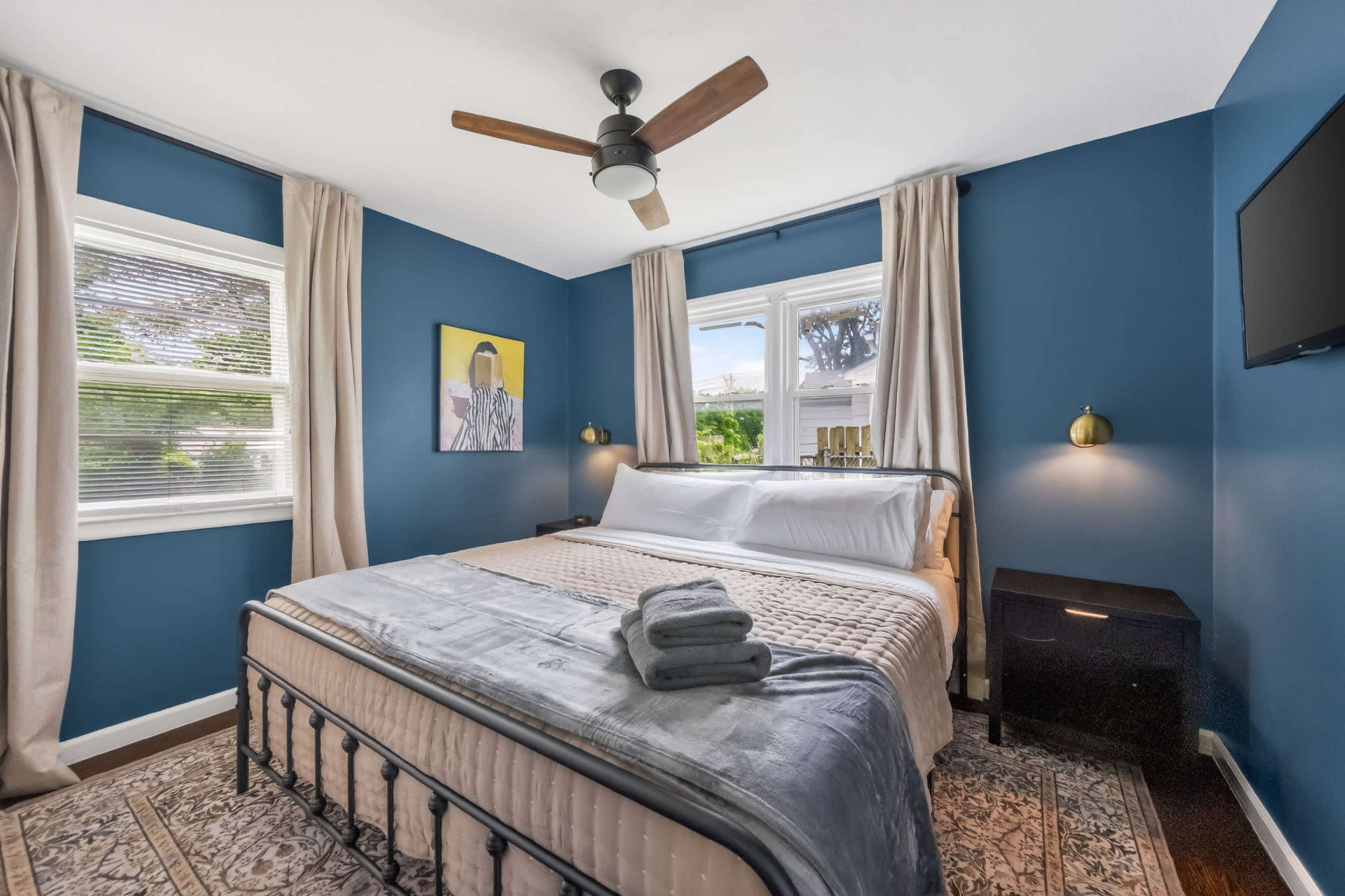 Moody Navy-Walled Bungalow with Bold Art & Backyard Image in Blue Township, Independence, MO