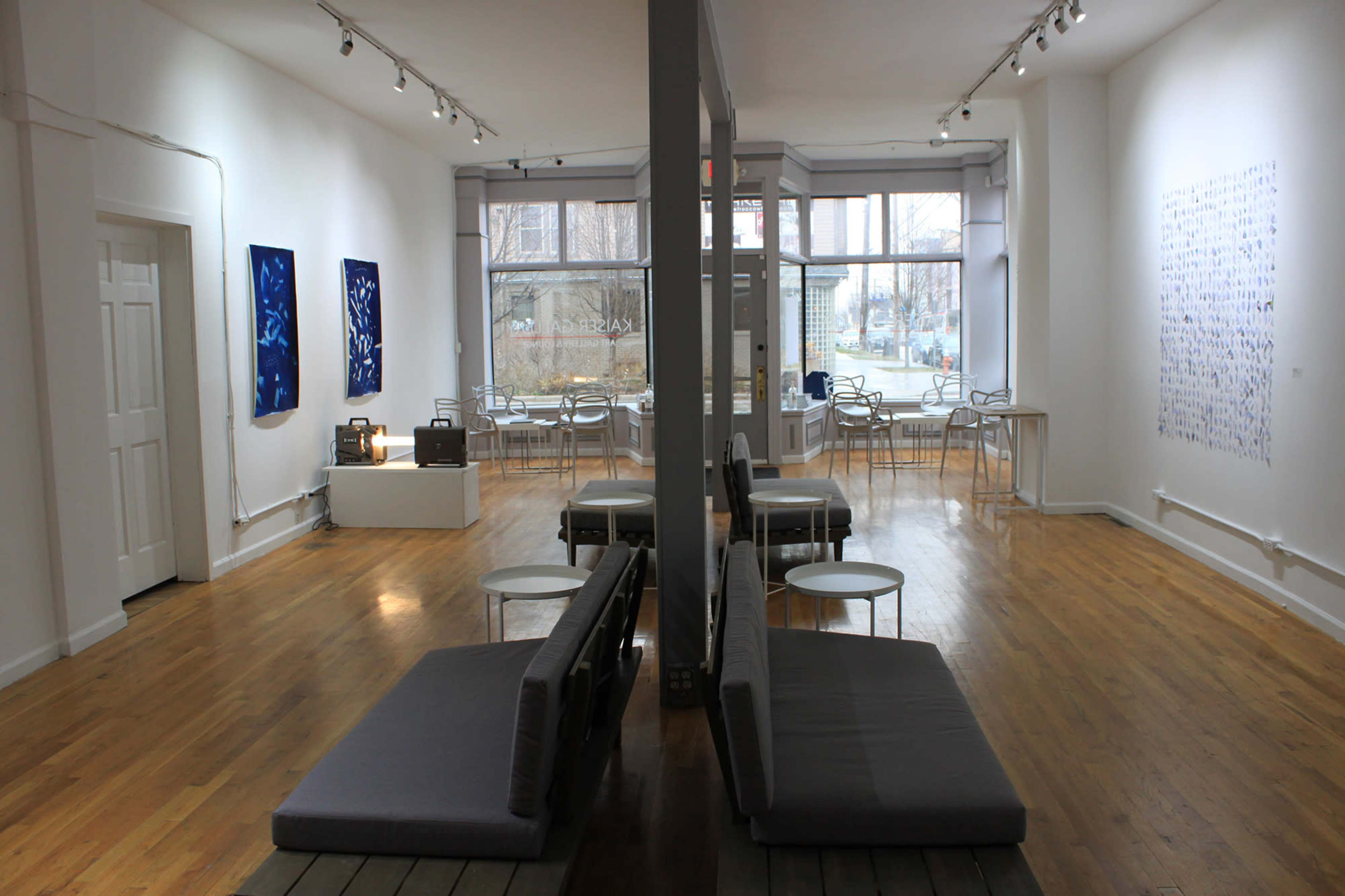 A modern art gallery with a spacious, light-filled interior featuring gallery seating and white walls adorned with art installations.