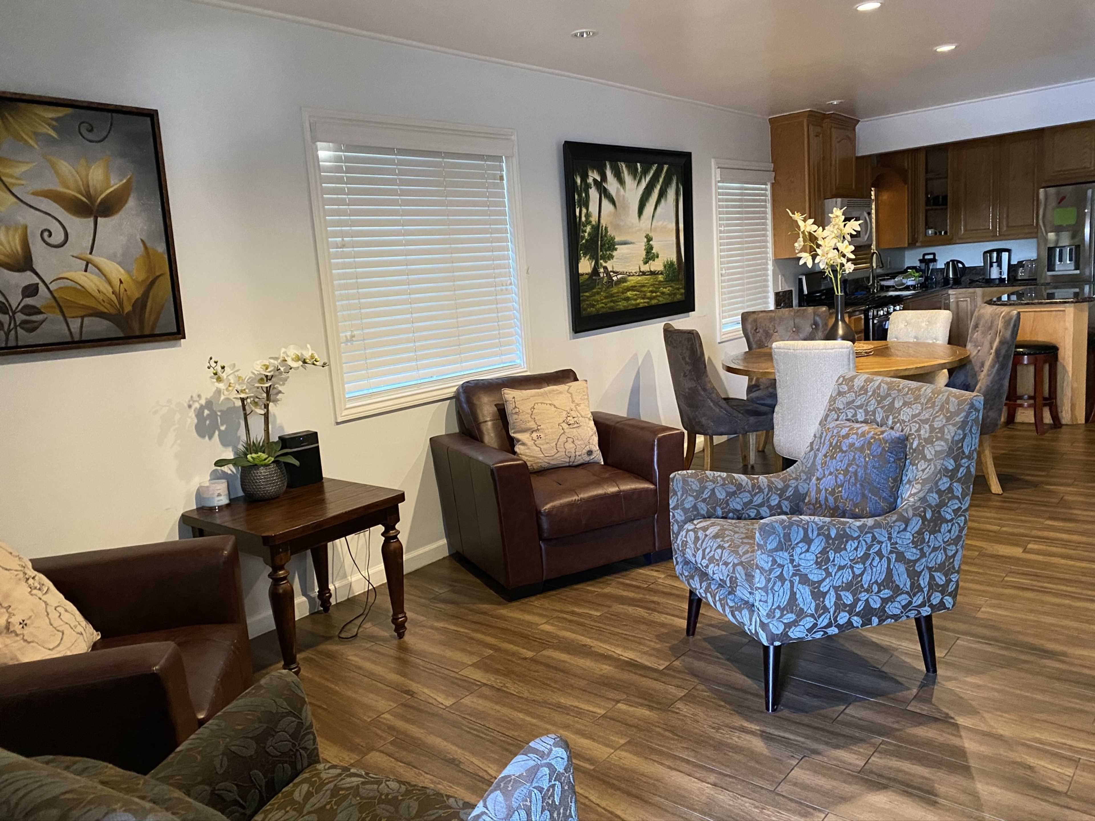 A cozy living area featuring upholstered chairs, a wooden table, and framed artwork on the walls.