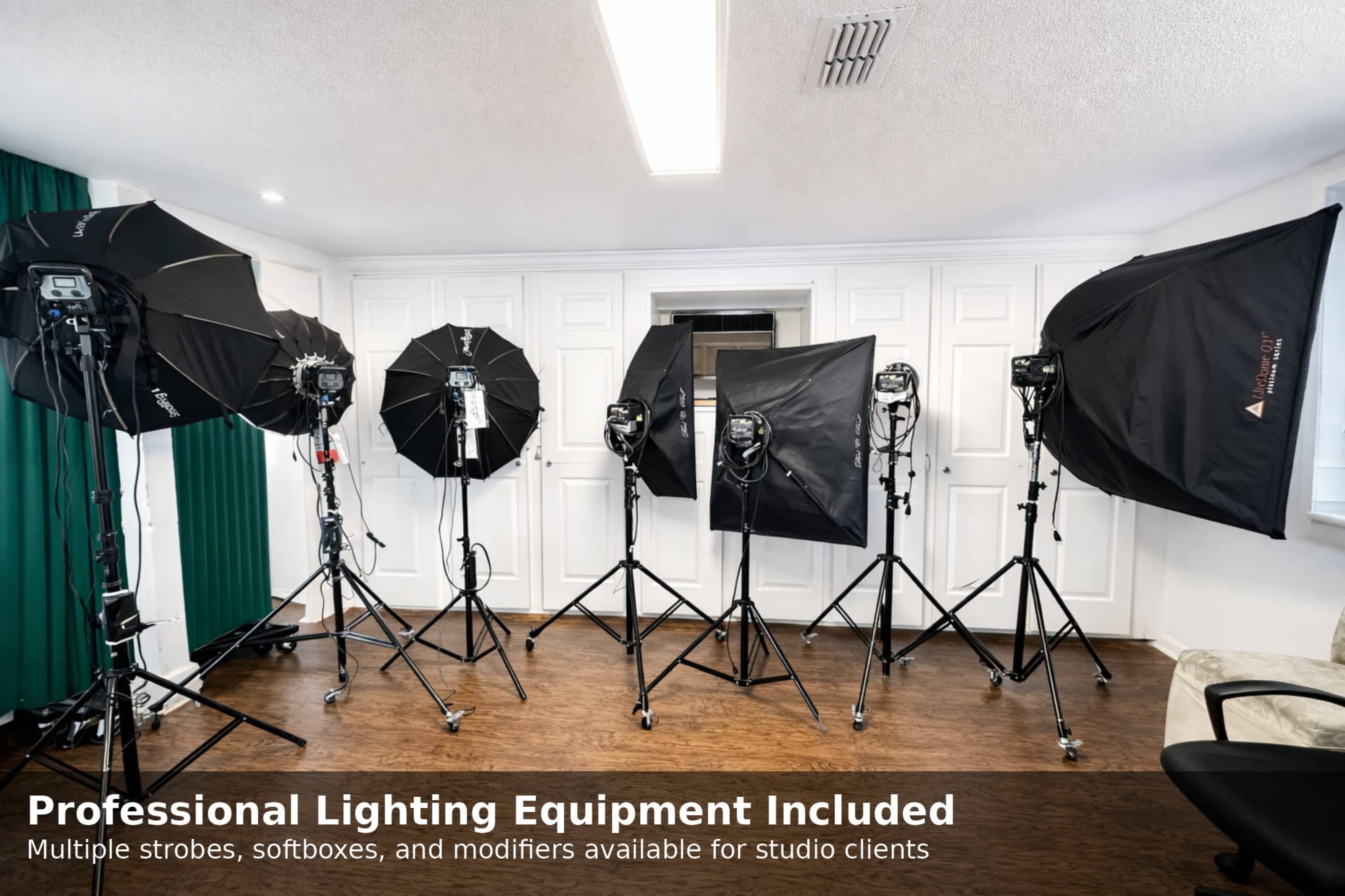 The image shows a photography studio setup featuring multiple lighting equipment, including softboxes and strobes arranged on stands against a backdrop of white cabinetry.