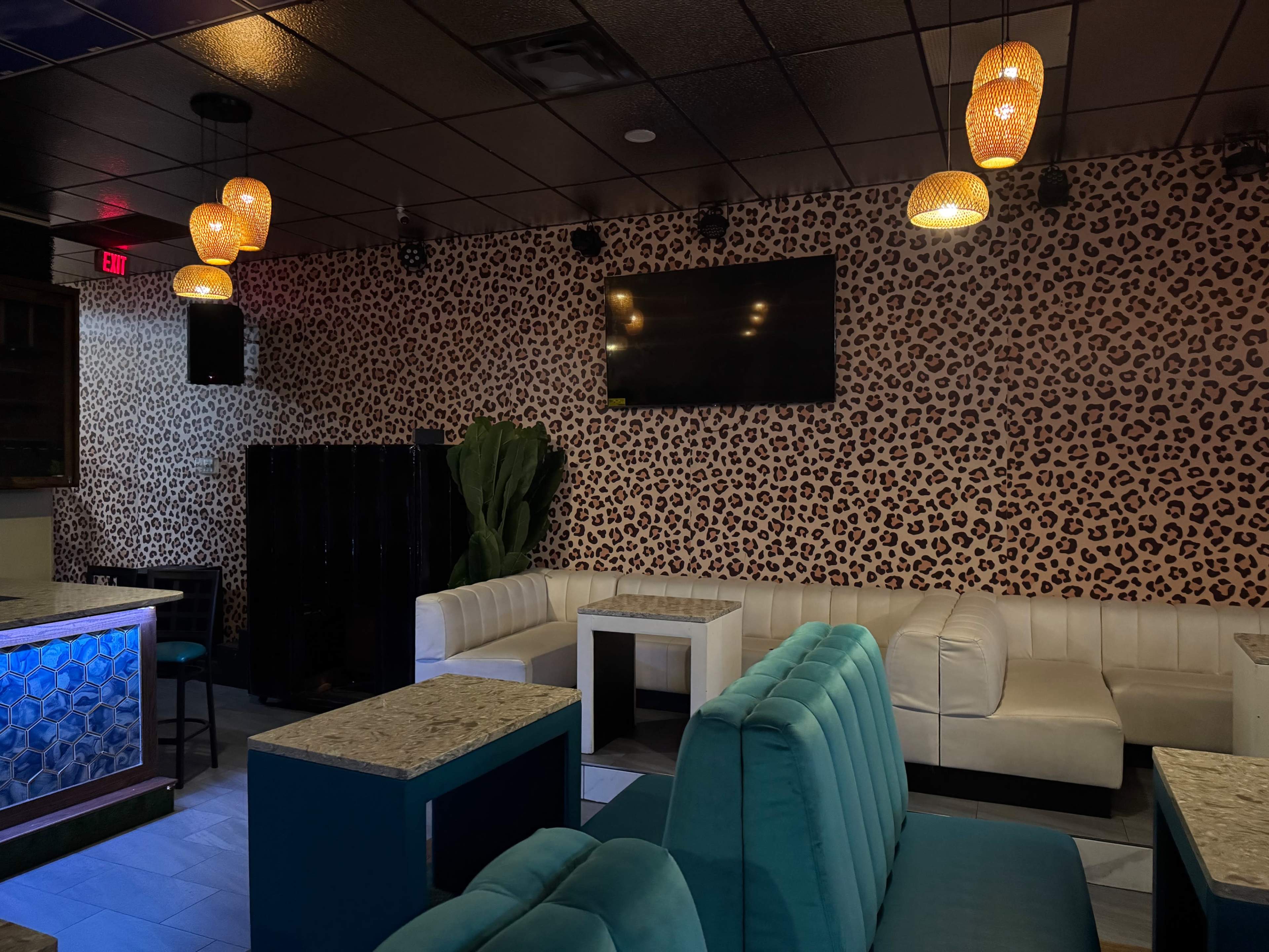The scene features a stylish lounge with leopard print wallpaper, a large wall-mounted TV, and seating areas that include plush sofas and tables.