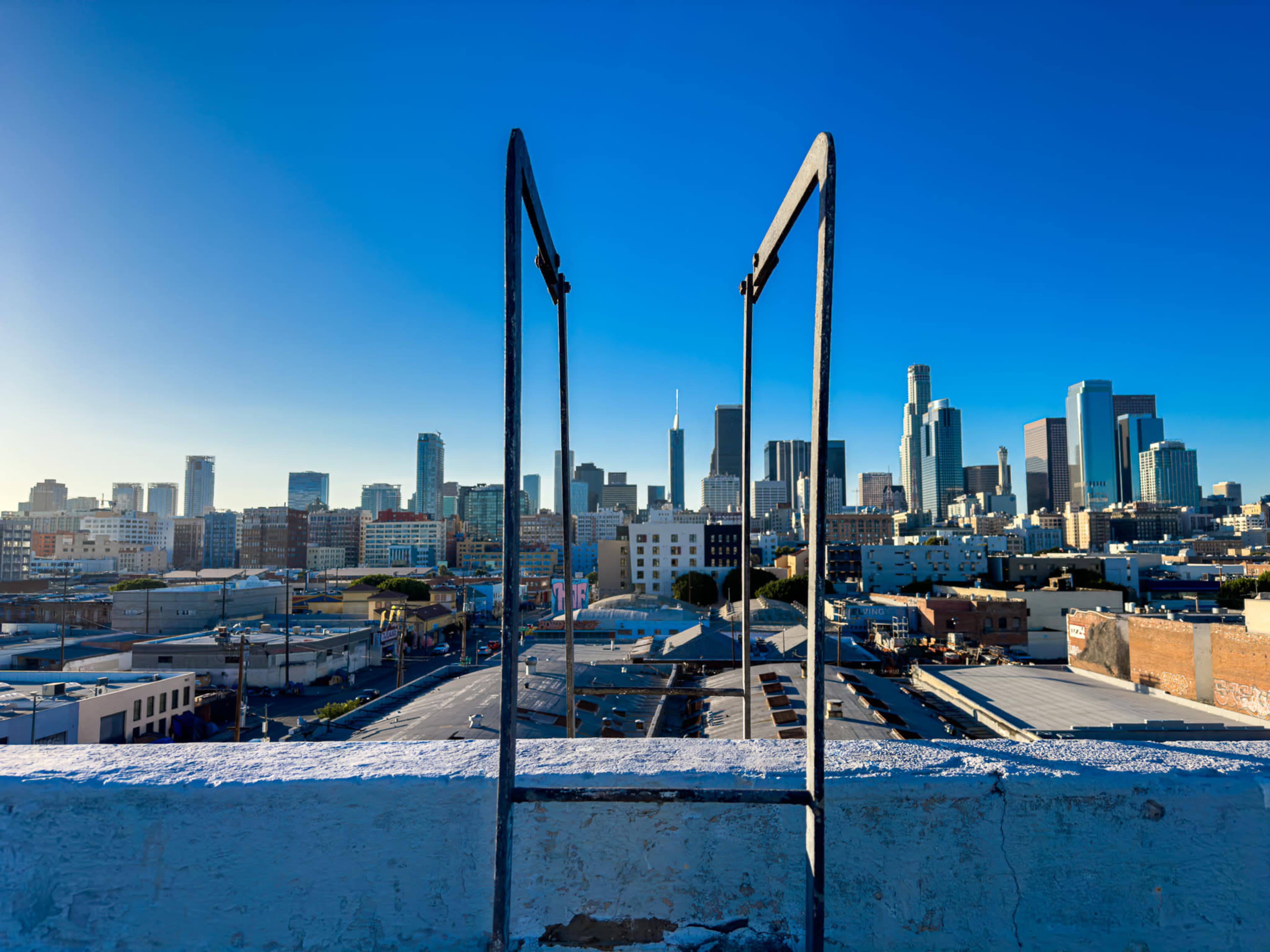 A view of a city skyline framed by a metal structure on a rooftop.