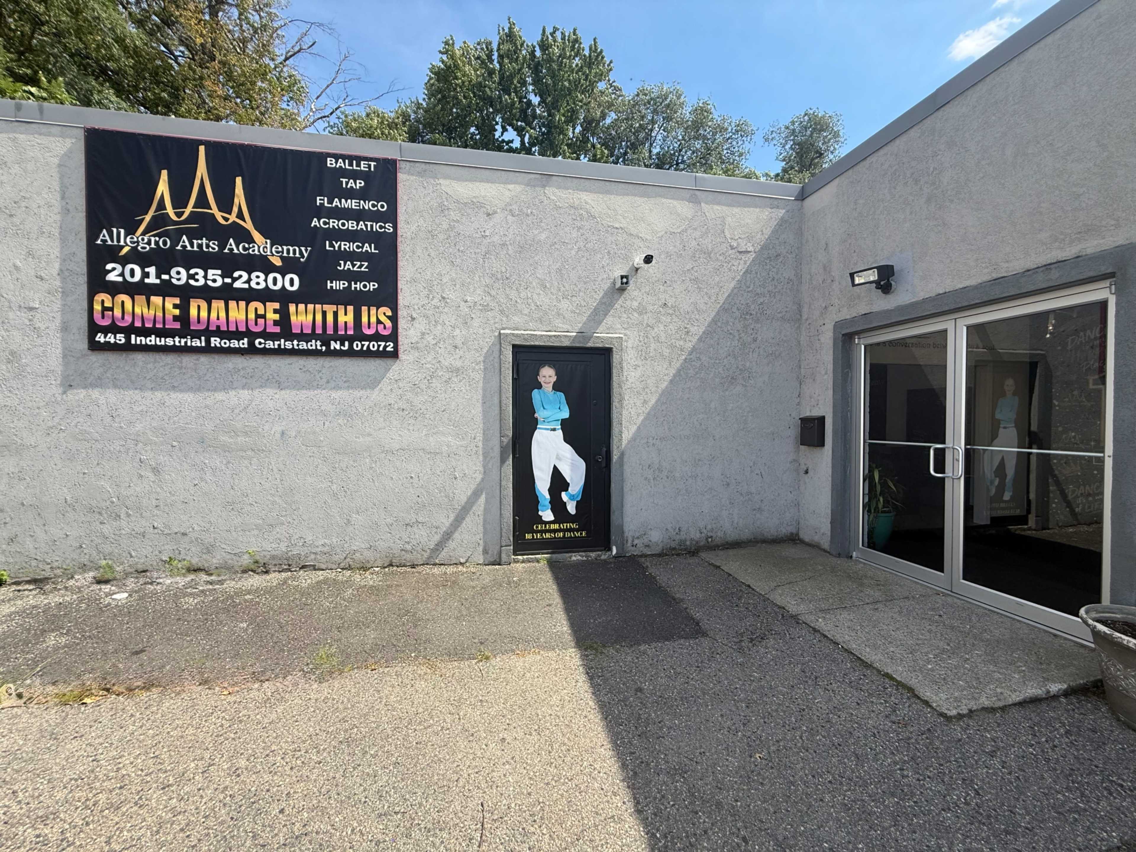 The image shows the exterior of Allegro Arts Academy, featuring a sign with contact information and a doorway adorned with a figure in dance attire.