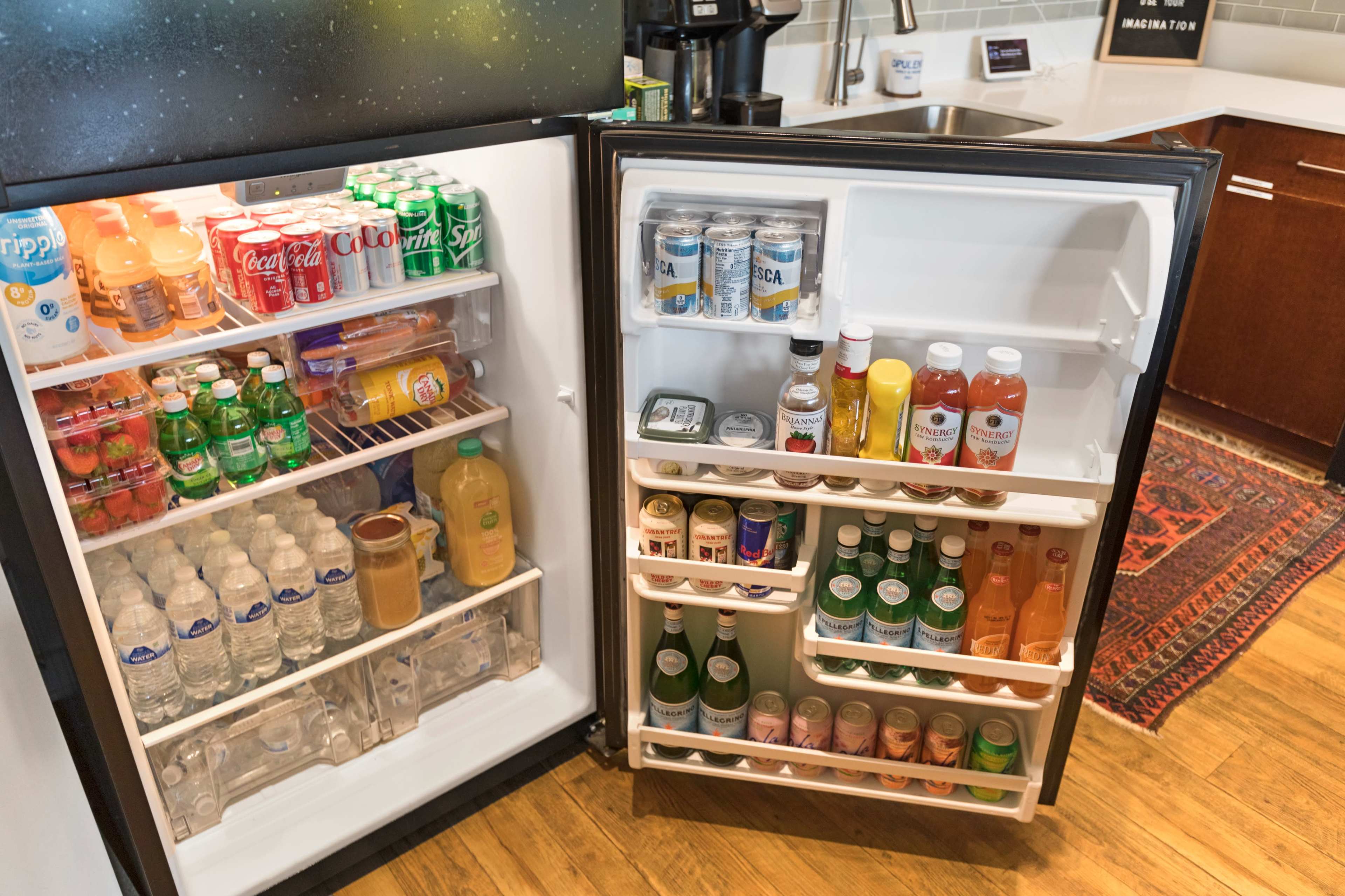 A refrigerator with a variety of beverages, including soft drinks, bottled water, and juices, organized on shelves.