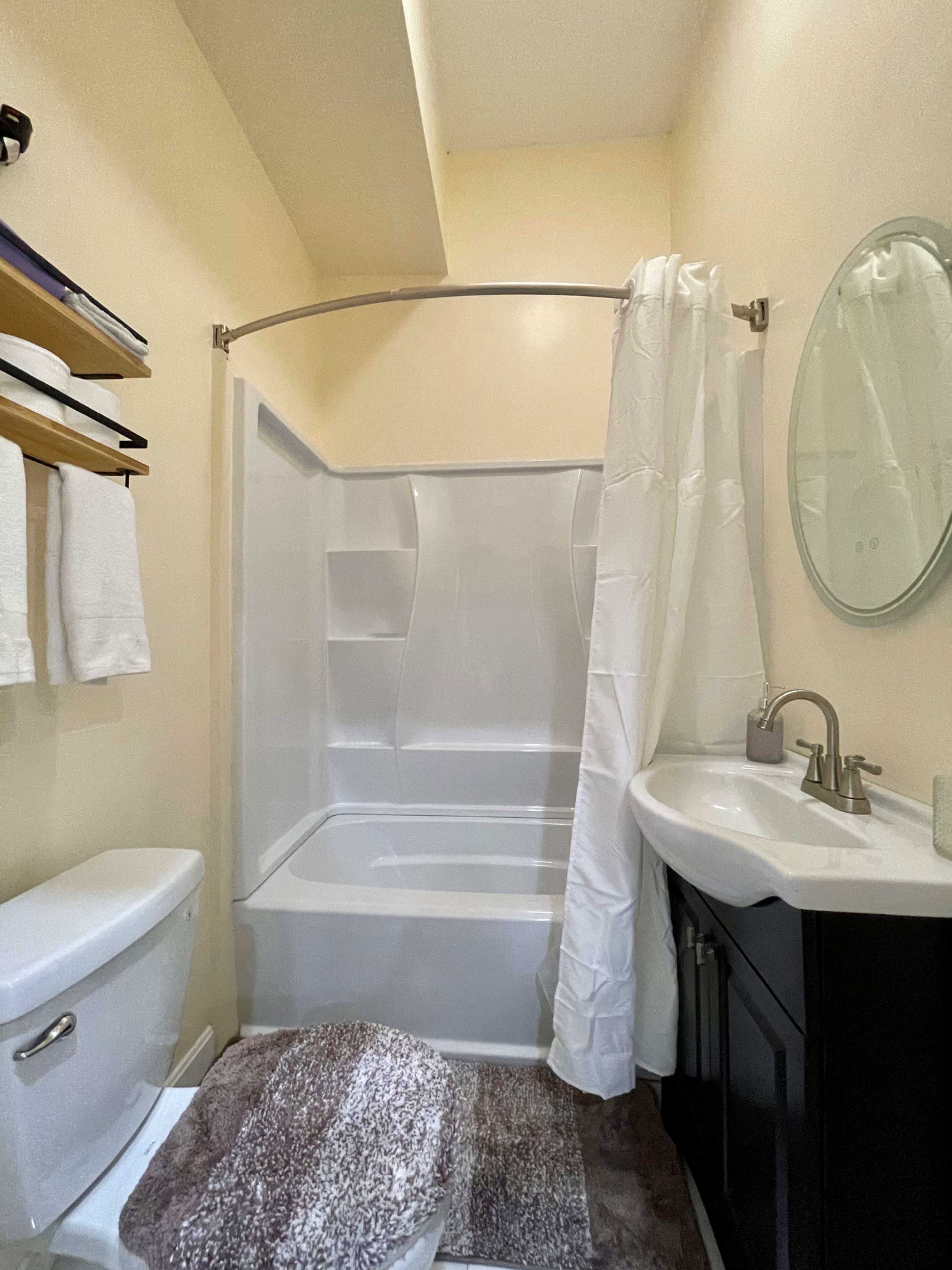 A bathroom with a toilet, sink, and a shower enclosed by a curtain.