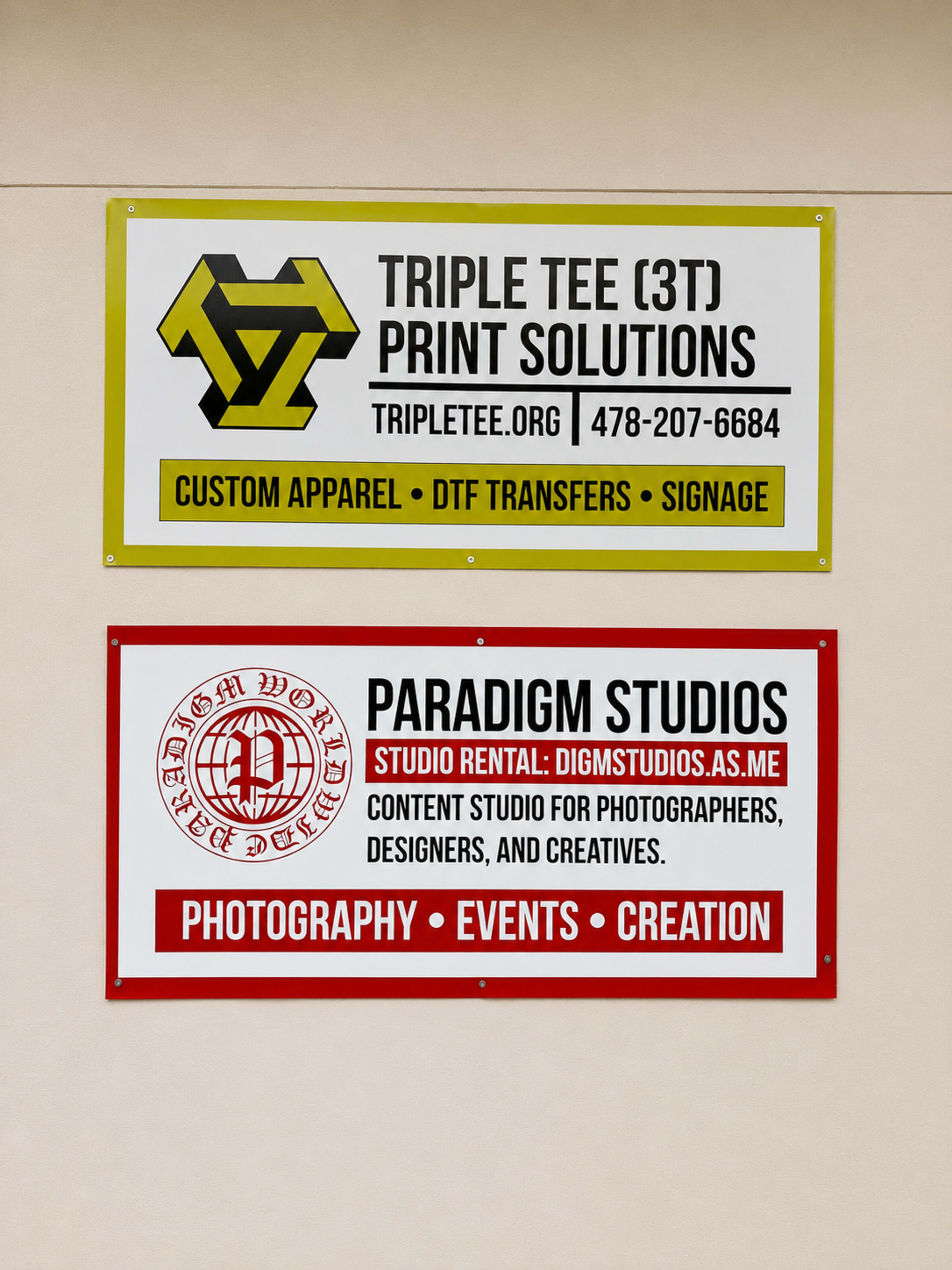 The image shows two horizontal banners on a wall, one advertising "Triple Tee Print Solutions" and the other "Paradigm Studios."
