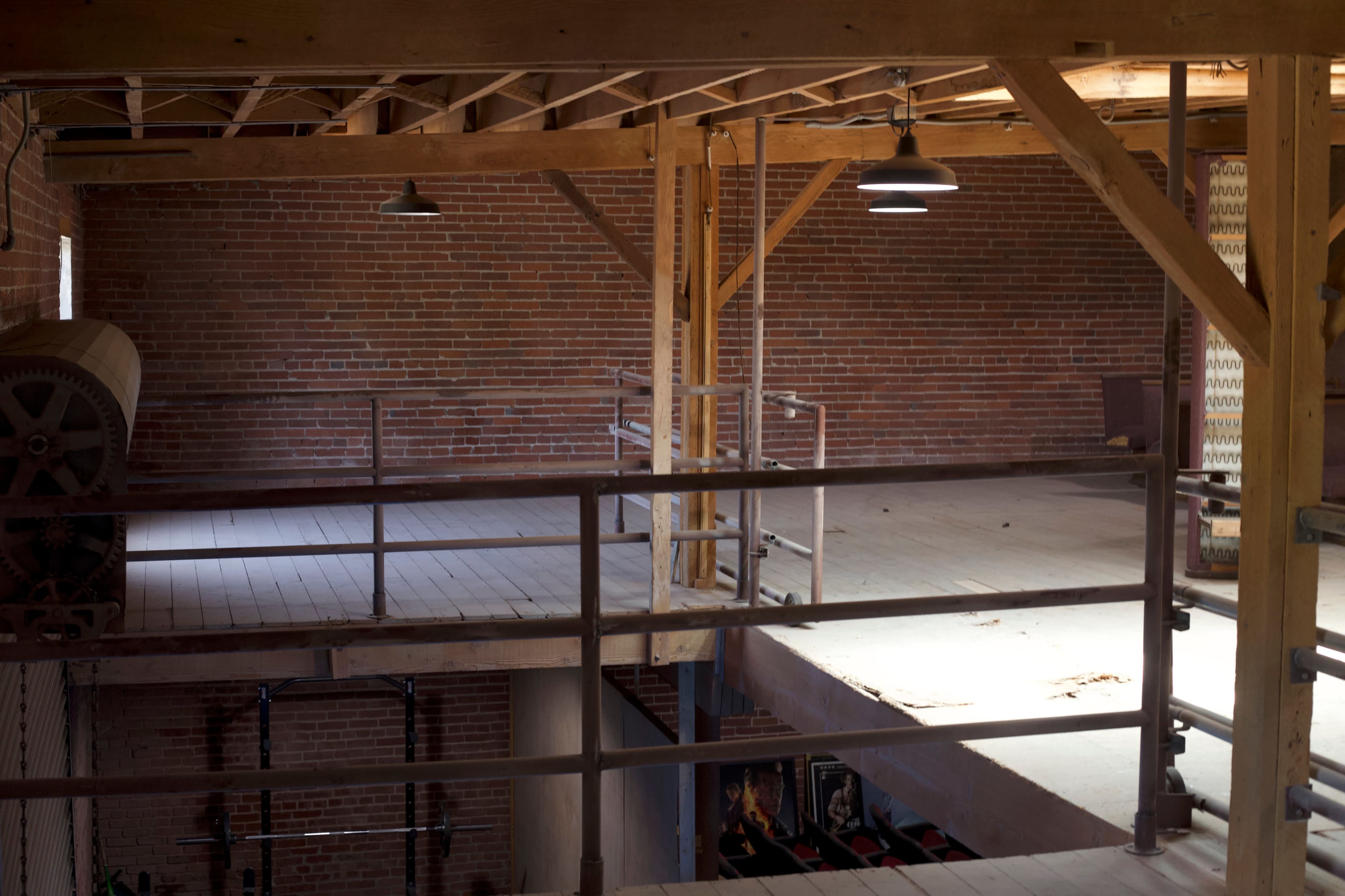 An interior of a spacious, industrial-style loft with exposed brick walls and wooden beams.