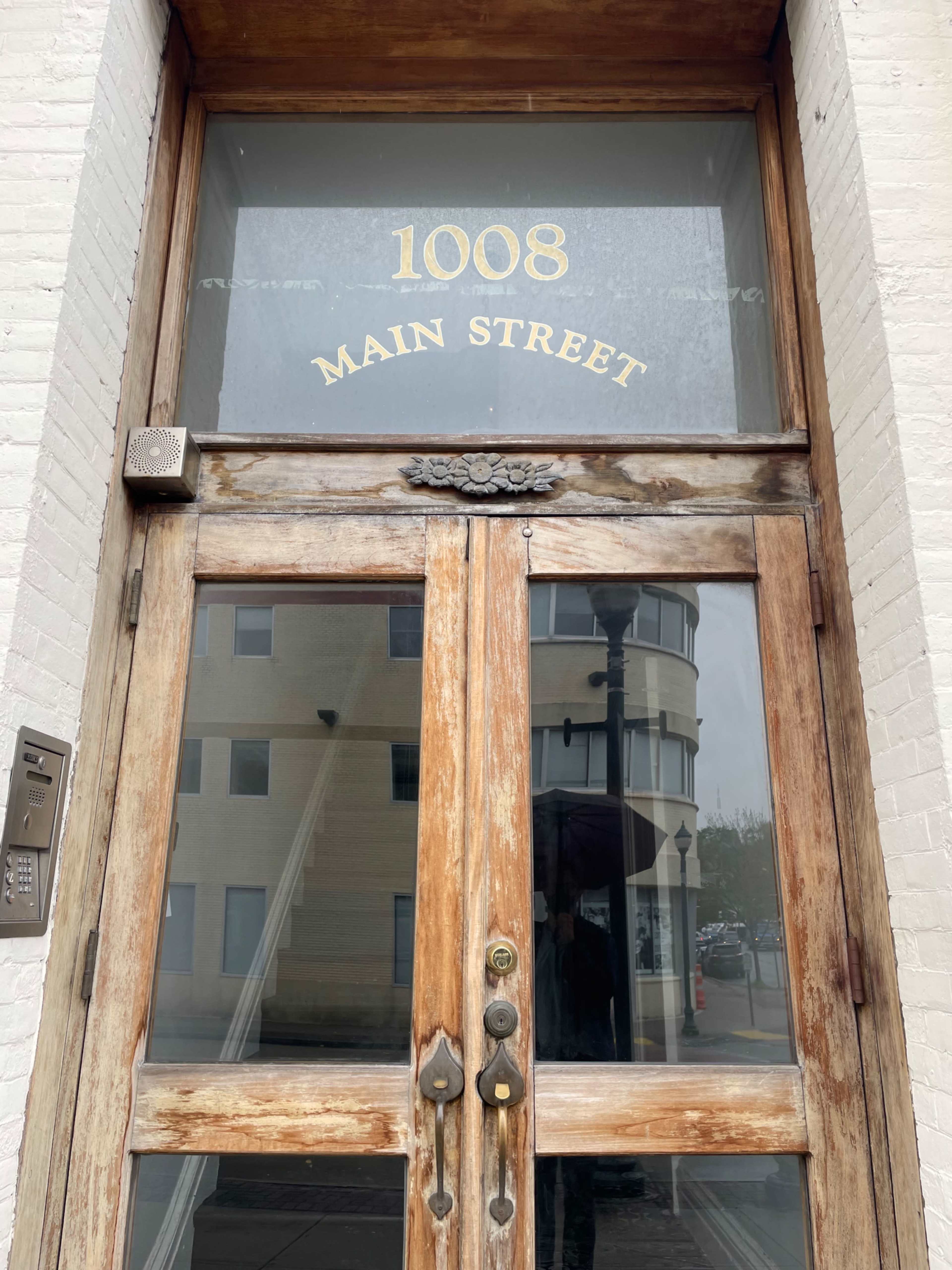 A wooden double door with the address "1008 MAIN STREET" engraved above it.