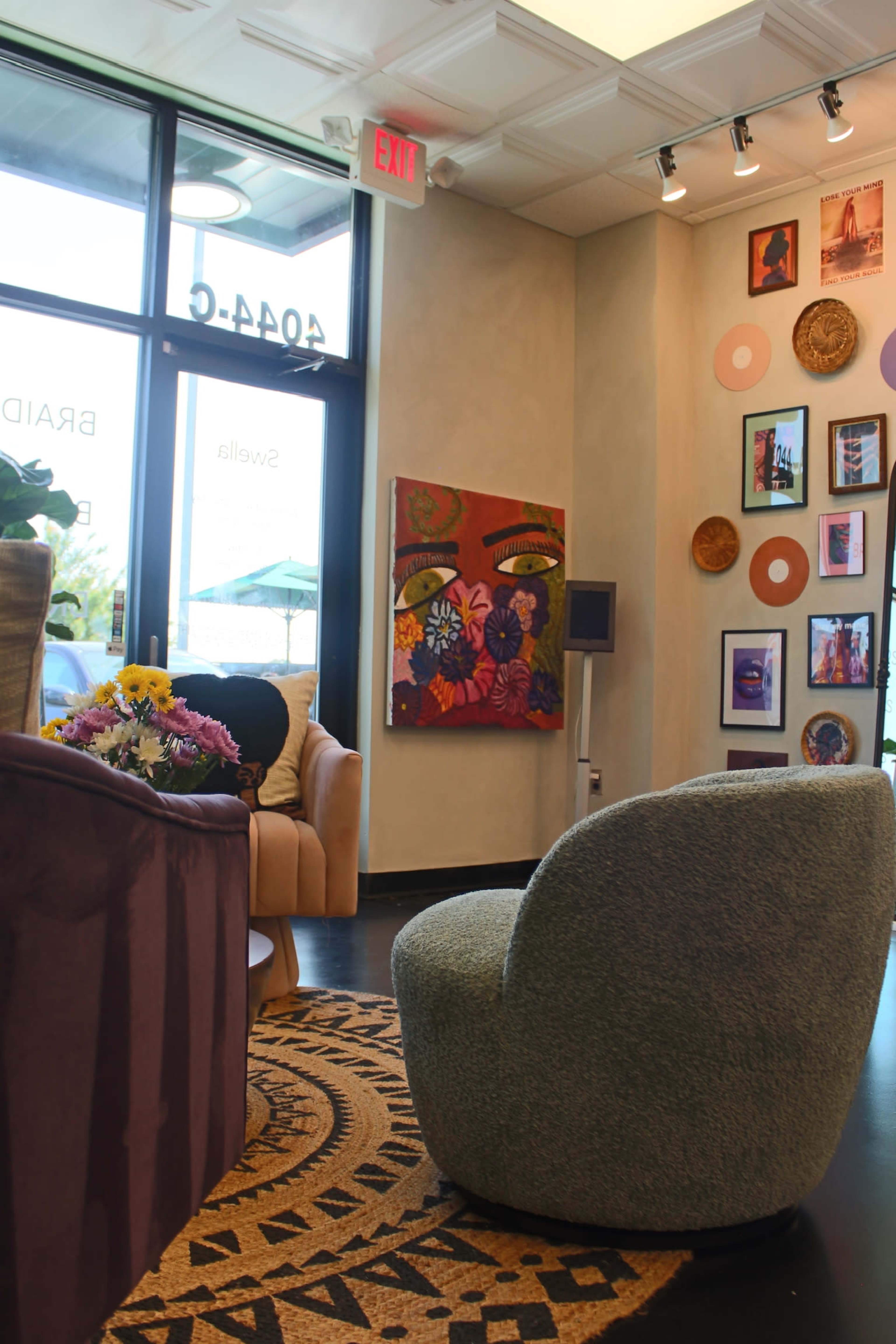 The image features a cozy salon interior with a patterned area rug, colorful wall art, and comfortable seating arrangements.
