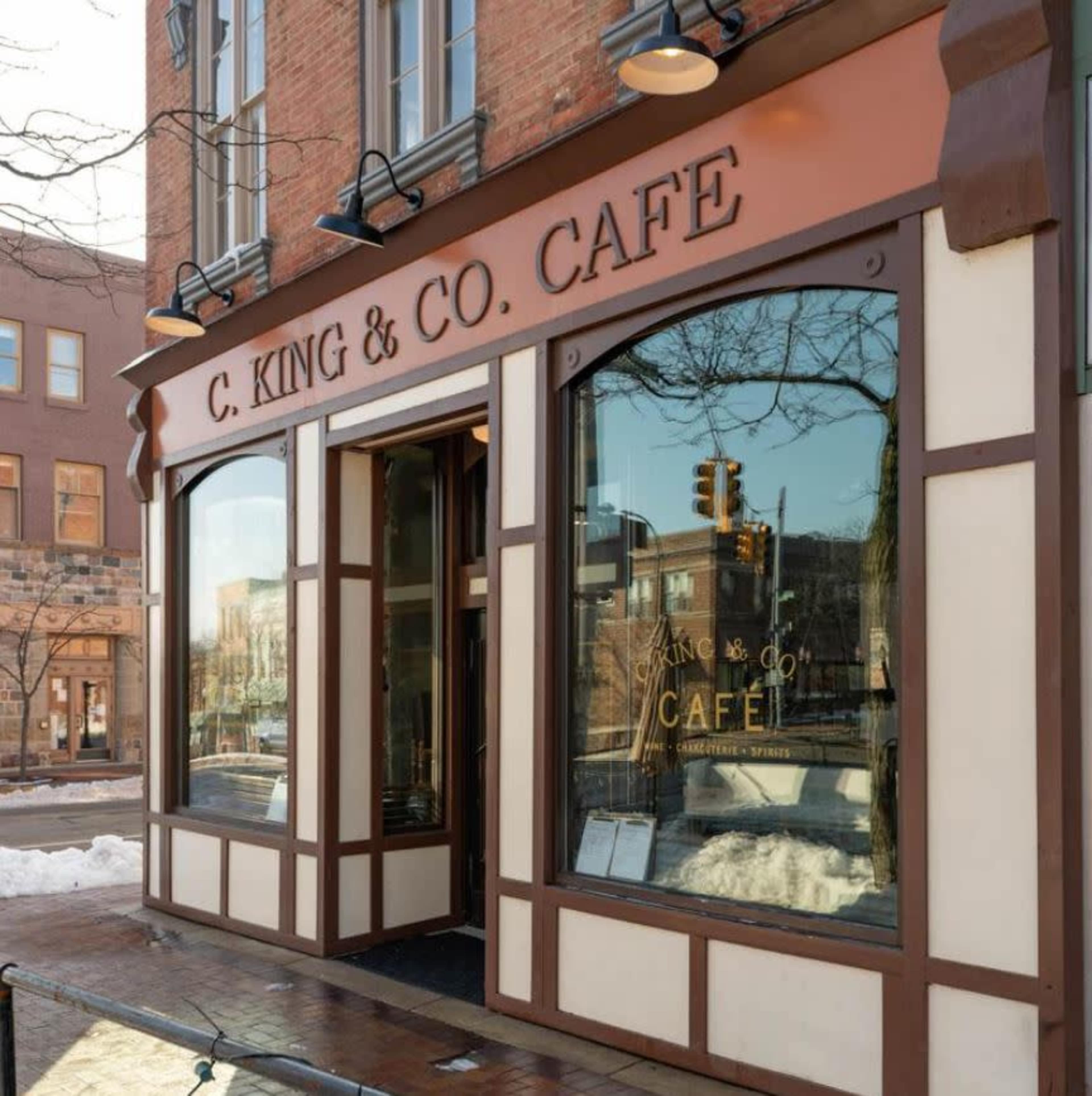 The image shows the exterior of C. King & Co. Café, featuring a storefront with large windows and a decorative sign.